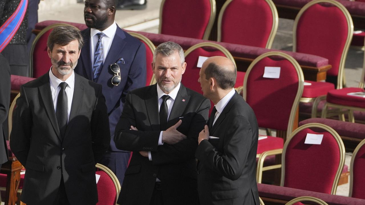 Prezident SR Peter Pellegrini (uprostred) a minister zahraničných vecí a európskych záležitostí SR Juraj Blanár (vľavo) stoja pri svojich stoličkách počas ich príchodu na pohreb zosnulého pápeža Františka na Námestí sv. Petra vo Vatikáne v sobotu 26. apríla 2025.