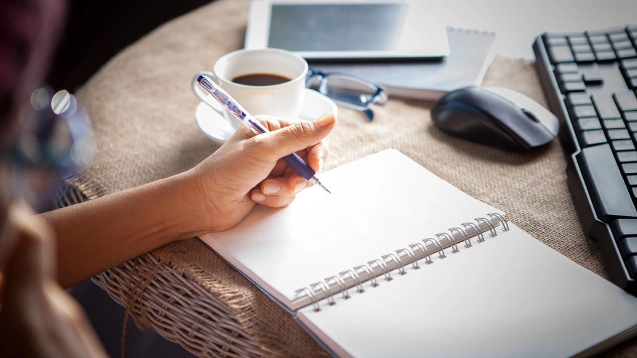 Woman,Left,Hand,Writing,On,Paper,Book,,on,Table,Shot