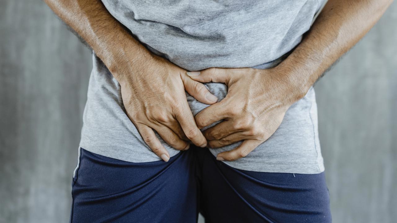 Young man holding his genitals; concept of pee holding, lack of toilet, prostate cancer, UTI or urinary tract infection