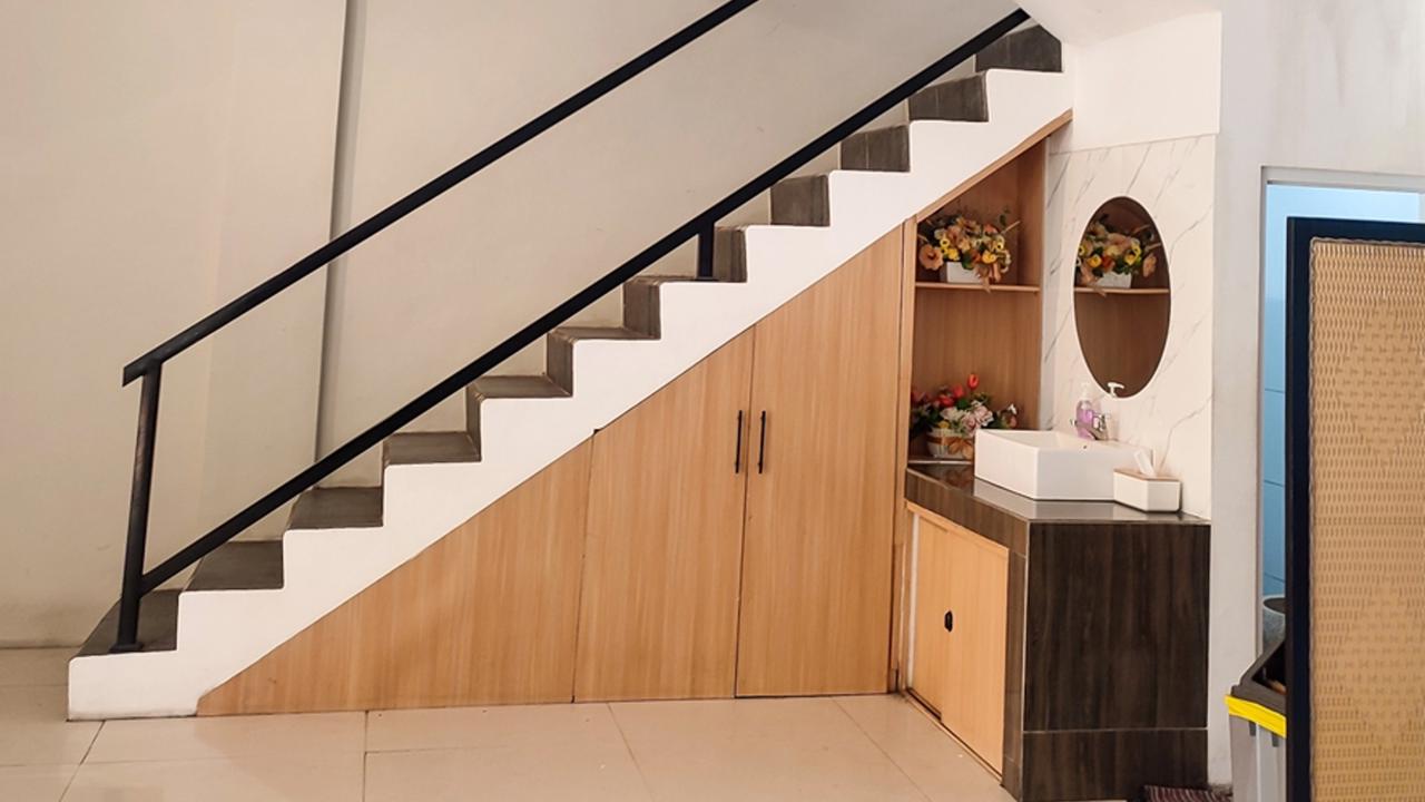 Wooden cabinet under the stairs, using the empty space under the stairs.  Negative space.  Contemporary Building Design with Modern Interior and Stylish Staircase