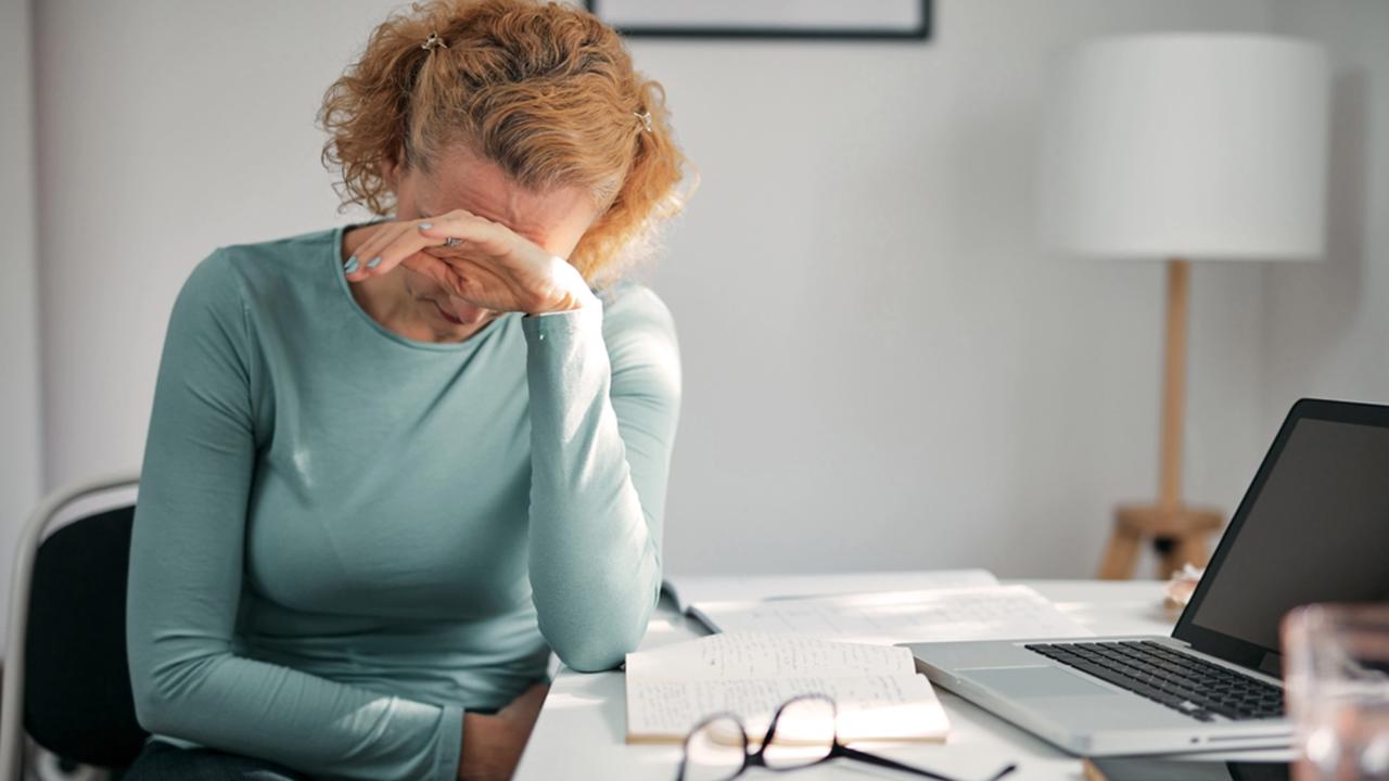 Woman with stomach spasm, cramp, headache, head pain, working from home troubles and issues.