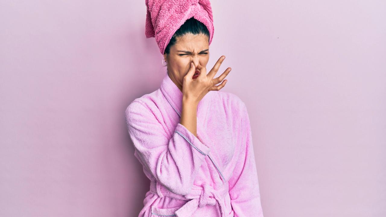Young,Hispanic,Woman,Wearing,Shower,Towel,Cap,And,Bathrobe,Smelling