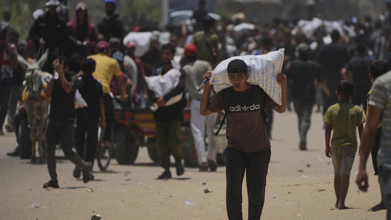 Palestínčania nesú tašky s potravinami a balíčkami humanitárnej pomoci v meste Rafah 9. júna 2025.