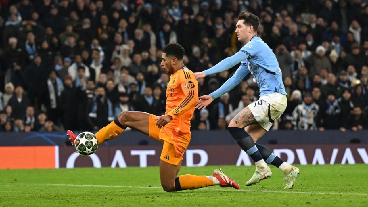  Jude Bellingham of Real Madrid scores his team's third goal whilst under pressure from John Stones of Manchester City during the UEFA Champions League 2024/25 League Knockout Play-off first leg match between Manchester City and Real Madrid C.F. at Manchester City Stadium on February 11, 2025 in Manchester, England. (Photo by Michael Regan/Getty Images)