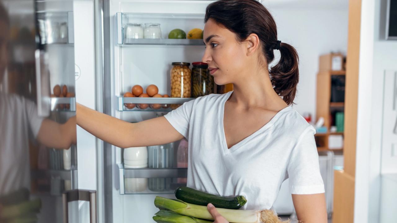 Shoot of beautiful young woman taking some healthy food from the fridge in the kitchen at home