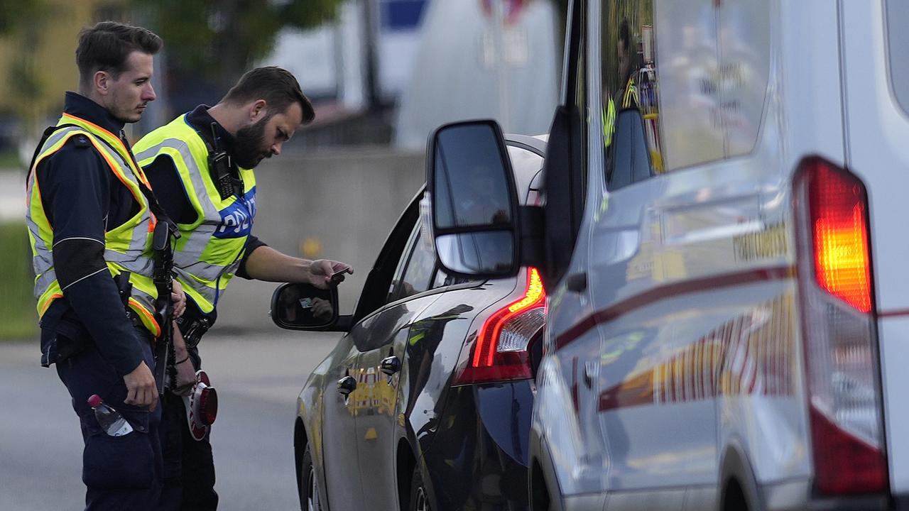 Policajti kontrolujú osobné auto na rakúskych hraniciach.
