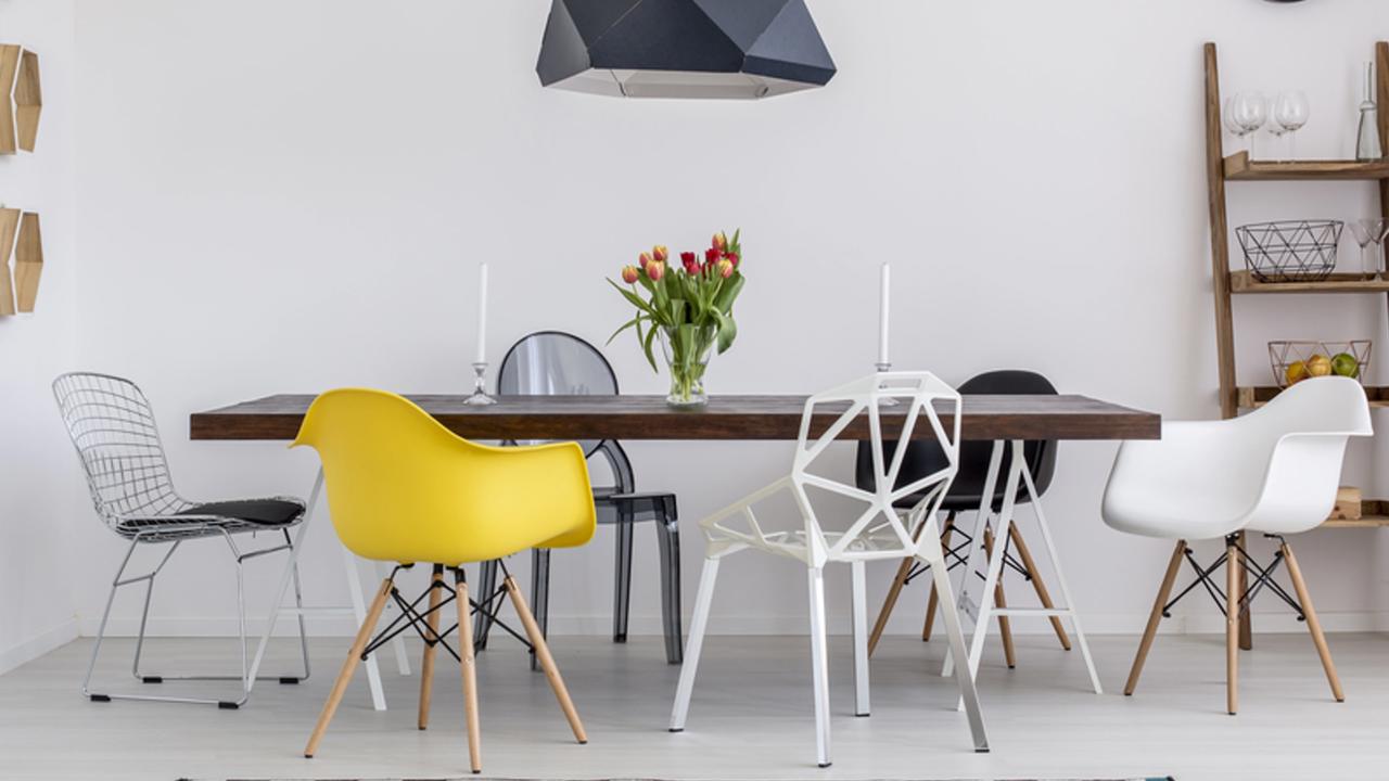 Beautiful white dining room with a large table and designer chairs