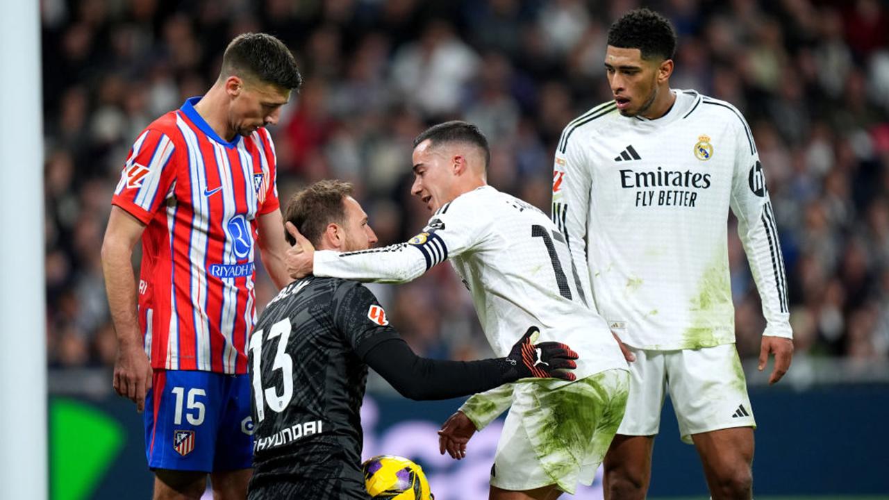 MADRID, SPAIN - FEBRUARY 08: Lucas Vazquez of Real Madrid embraces Jan Oblak of Atletico de Madrid, as Jude Bellingham of Real Madrid and Clement Lenglet of Atletico de Madrid look on during the LaLiga match between Real Madrid CF and Atletico de Madrid at Estadio Santiago Bernabeu on February 08, 2025 in Madrid, Spain. (Photo by Angel Martinez/Getty Images)