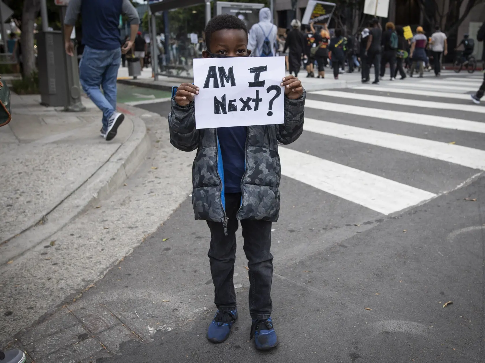 KK6 Los Angeles - Chlapec drží papier s nápisom "Som ďalší ?" počas protestu proti policajnému zásahu 29. mája 2020 v Los Angeles. Protesty proti smrti neozbrojeného muža čiernej pleti, ktorý v americkom meste Minneaopolis, štát Minnesota, zomrel po zásahu belošského policajta, pokračovali aj napriek zákazu vychádzania až do piatkových neskorých večerných hodín, pričom nepokoje vypukli aj v ďalších mestách na území Spojených štátov. Afroameričana menom George Floyd zatkla polícia v pondelok veče