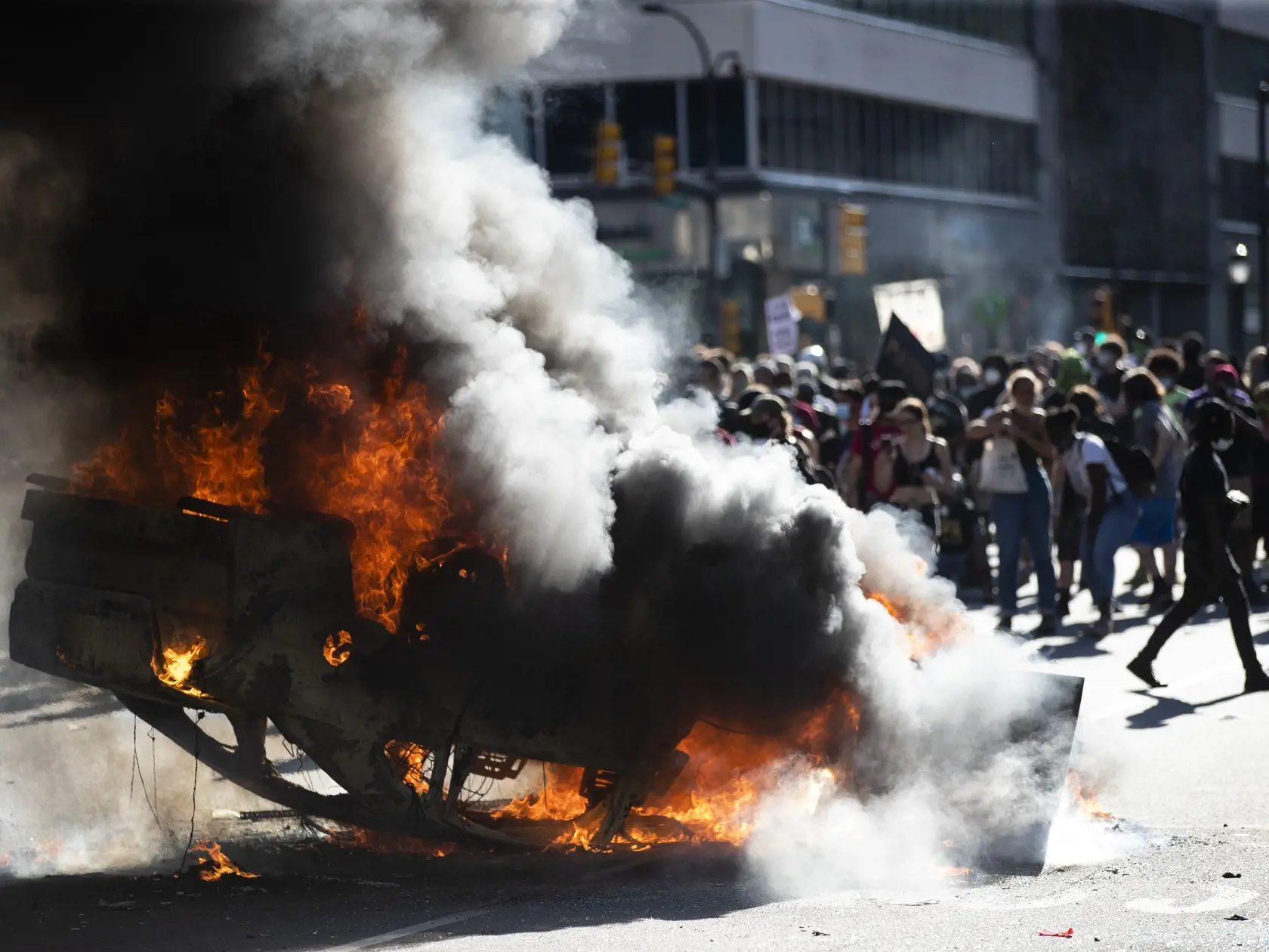 KK17 Philadelphia - Na snímke horiace auto počas pokračujúcich protestov proti zásahu polície sobotu 30. mája 2020 vo Philadelphii. Afroameričana menom George Floyd zatkla polícia v pondelok večer. Videozáznam zhotovený okolostojacimi ľuďmi zachytáva spútaného muža ležiaceho na zemi. Jeden z policajtov v kľaku tlačil kolenom na Floydov krk. Zatknutý upozorňoval na bolesť a kričal, že nemôže dýchať. Krátko na to zomrel v nemocnici. FOTO TASR/AP
Smoke rises from a fire on a police cruiser in Cente