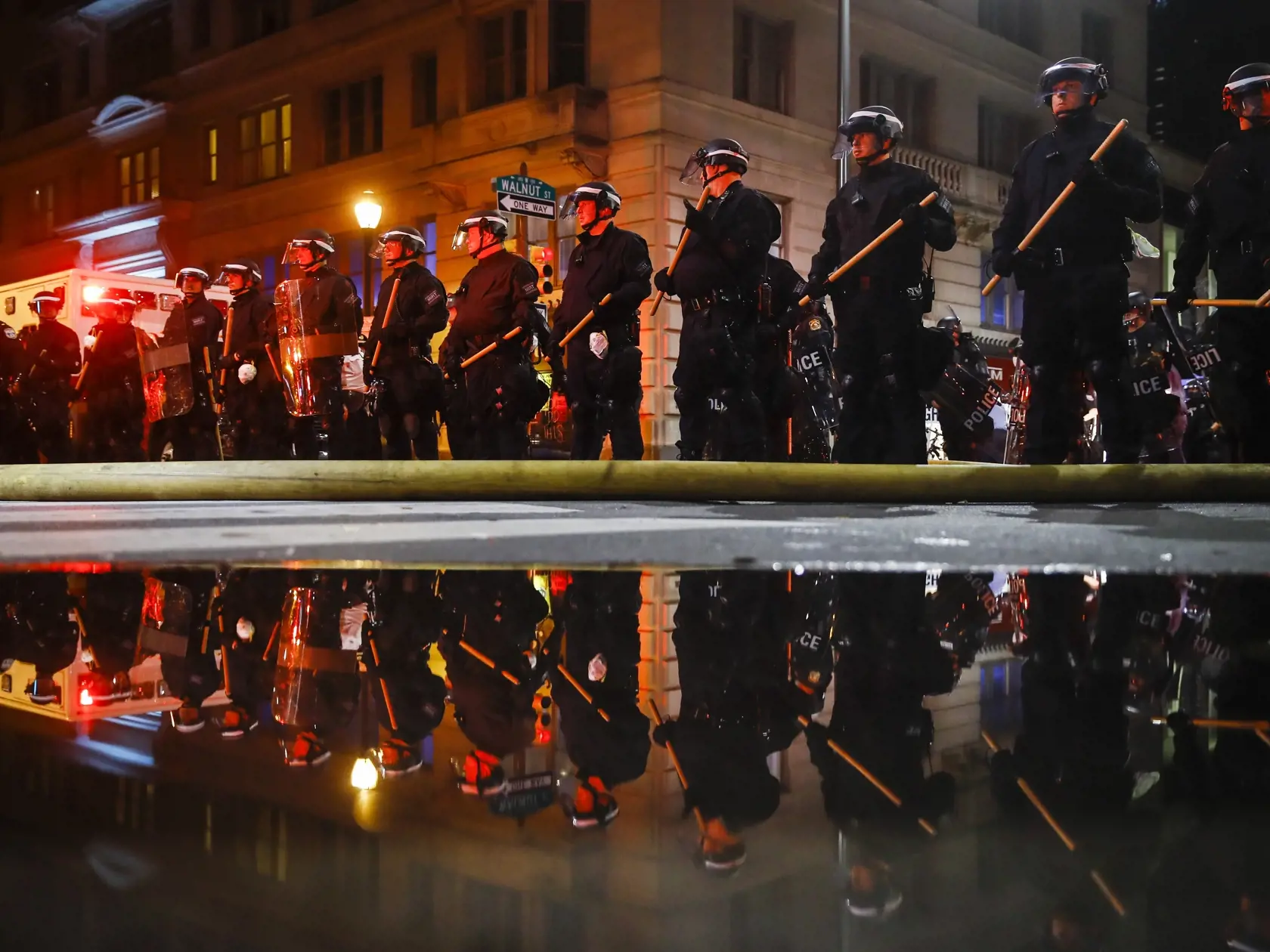 KK19 Philadelphia - Na snímke odraz policajtov, ktorí hliadkujú počas pokračujúcich protestov proti zásahu polície sobotu 30. mája 2020 vo Philadelphii. Afroameričana menom George Floyd zatkla polícia v pondelok večer. Videozáznam zhotovený okolostojacimi ľuďmi zachytáva spútaného muža ležiaceho na zemi. Jeden z policajtov v kľaku tlačil kolenom na Floydov krk. Zatknutý upozorňoval na bolesť a kričal, že nemôže dýchať. Krátko na to zomrel v nemocnici. FOTO TASR/AP
Police are reflected as they st