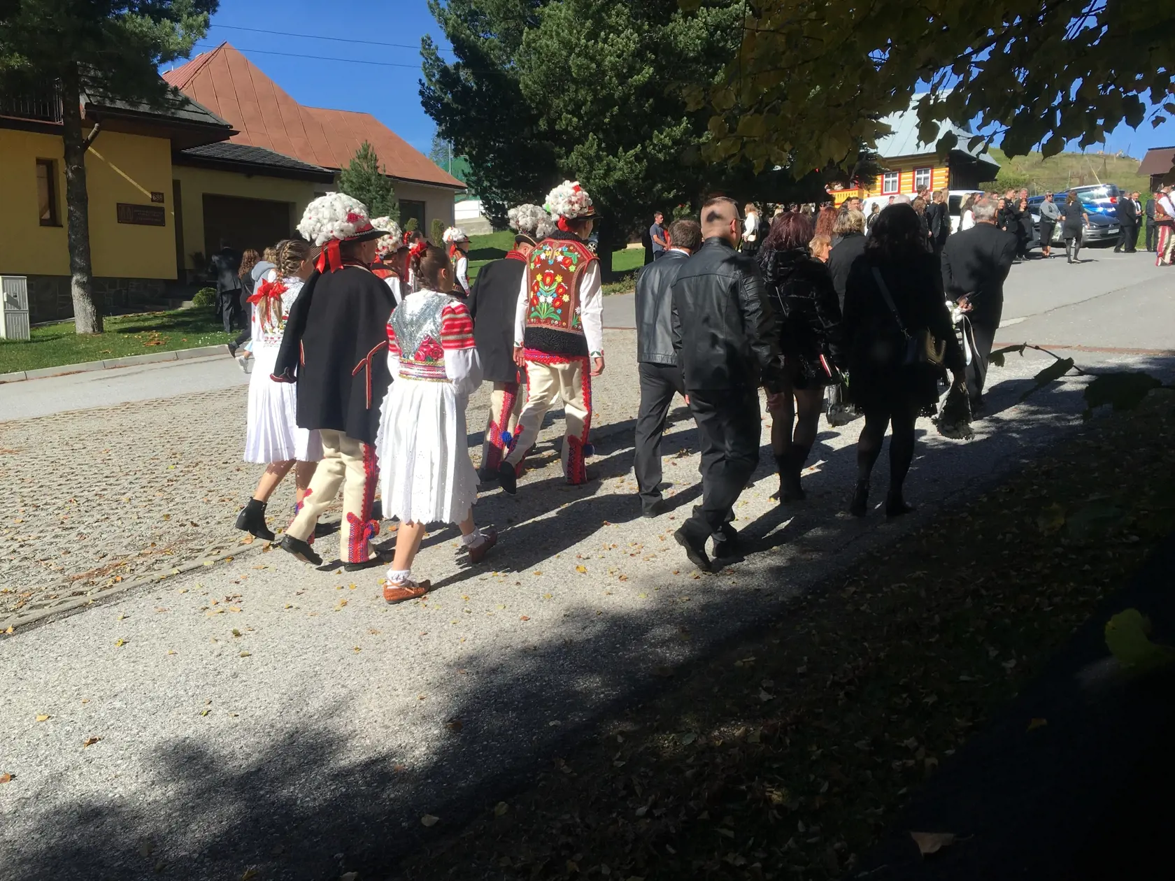 Ľudia sa schádzajú na pohreb.  
