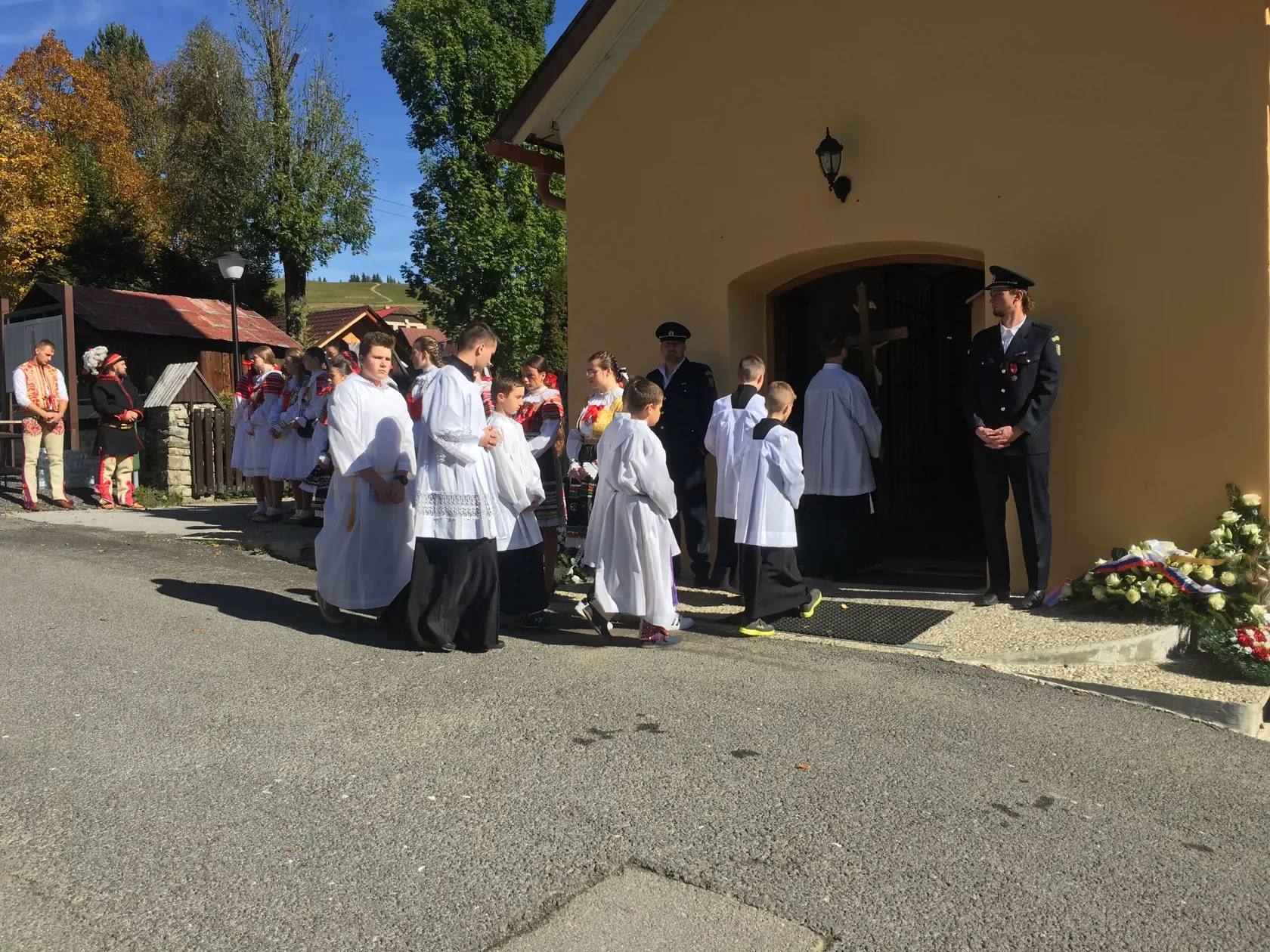 Miništranti s kňazom vchádzajú do kostola. 