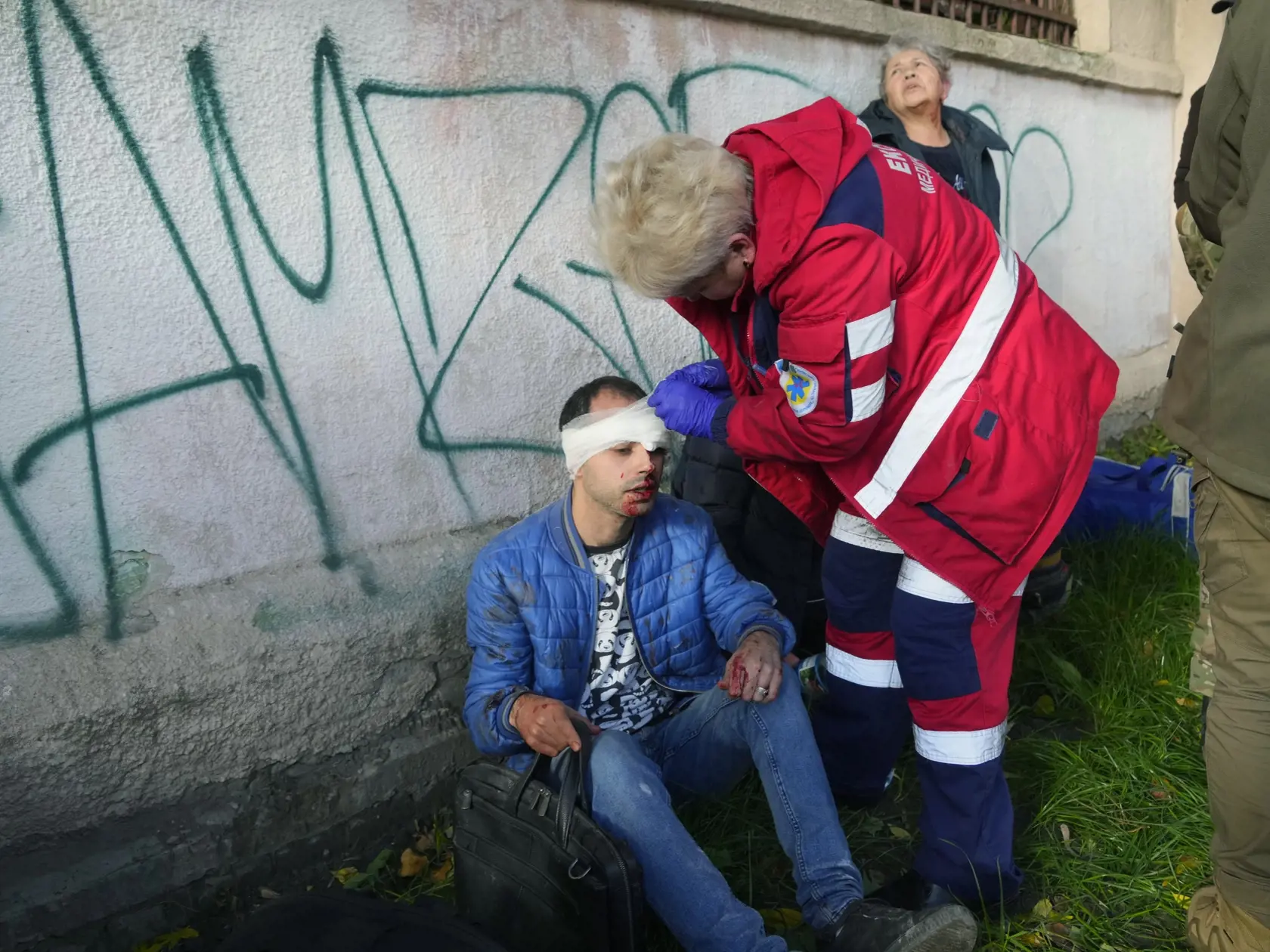 Na snímke zranený muž počas lekárskeho ošetrenia na mieste ruského útoku v Kyjeve 10. októbra 2022. Viacero explózií bolo po niekoľkých mesiacoch relatívne pokojnej situácie počuť v pondelok ráno v ukrajinskej metropole Kyjev.