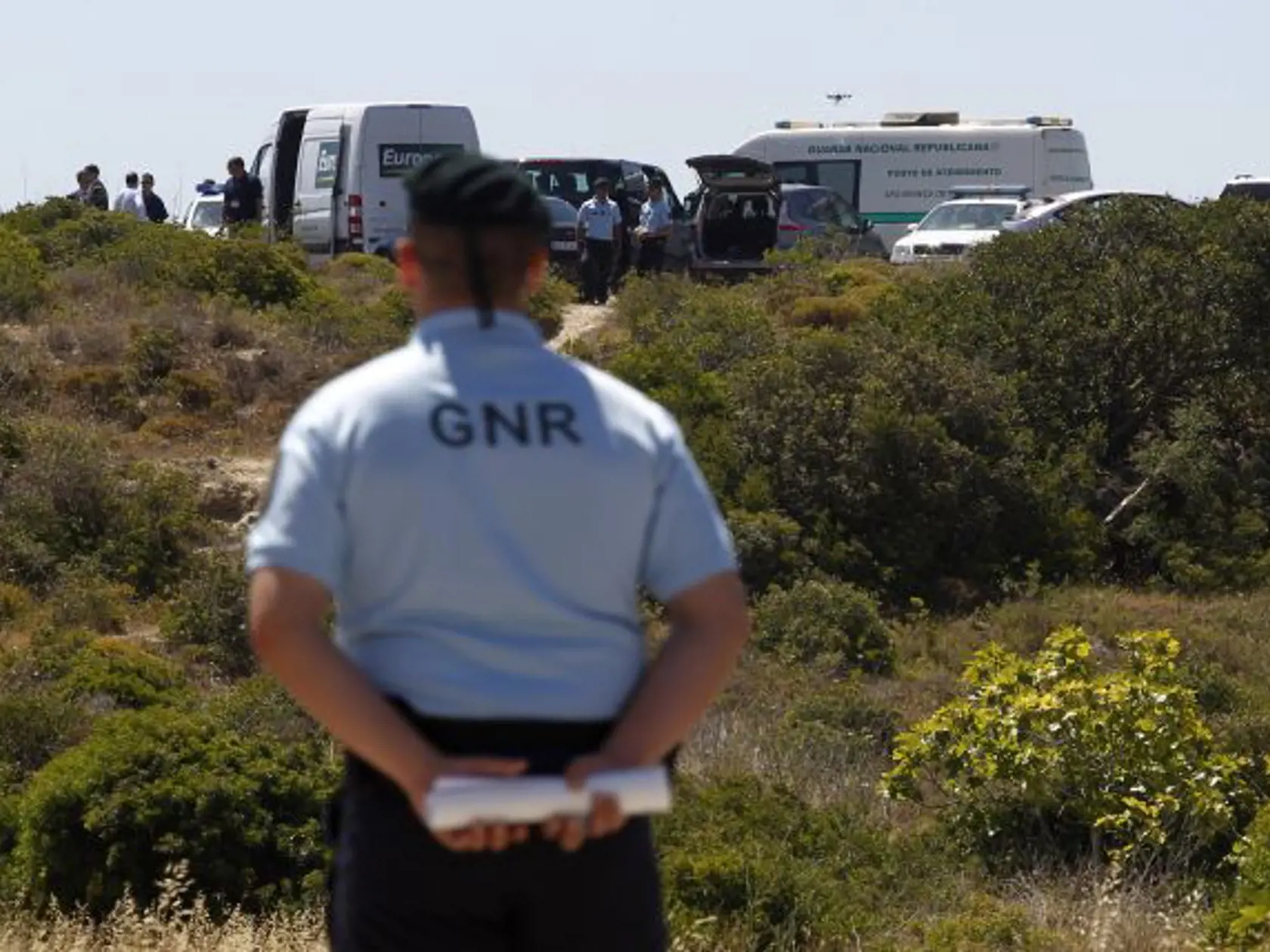 Portuguese Republican Guard policemen and other officers stand guard in a cordoned-off area, in Praia da Luz, Lagos, southern Portugal, Monday, June 2, 2014. Police investigating the disappearance of Madeleine McCann cordoned off Monday an area of scrubland near where the British girl vanished seven years ago. Officers placed yellow-and-white police tape around the waste ground, which is mostly level and slightly larger than a soccer field, and were expected to conduct a forensic examination of 