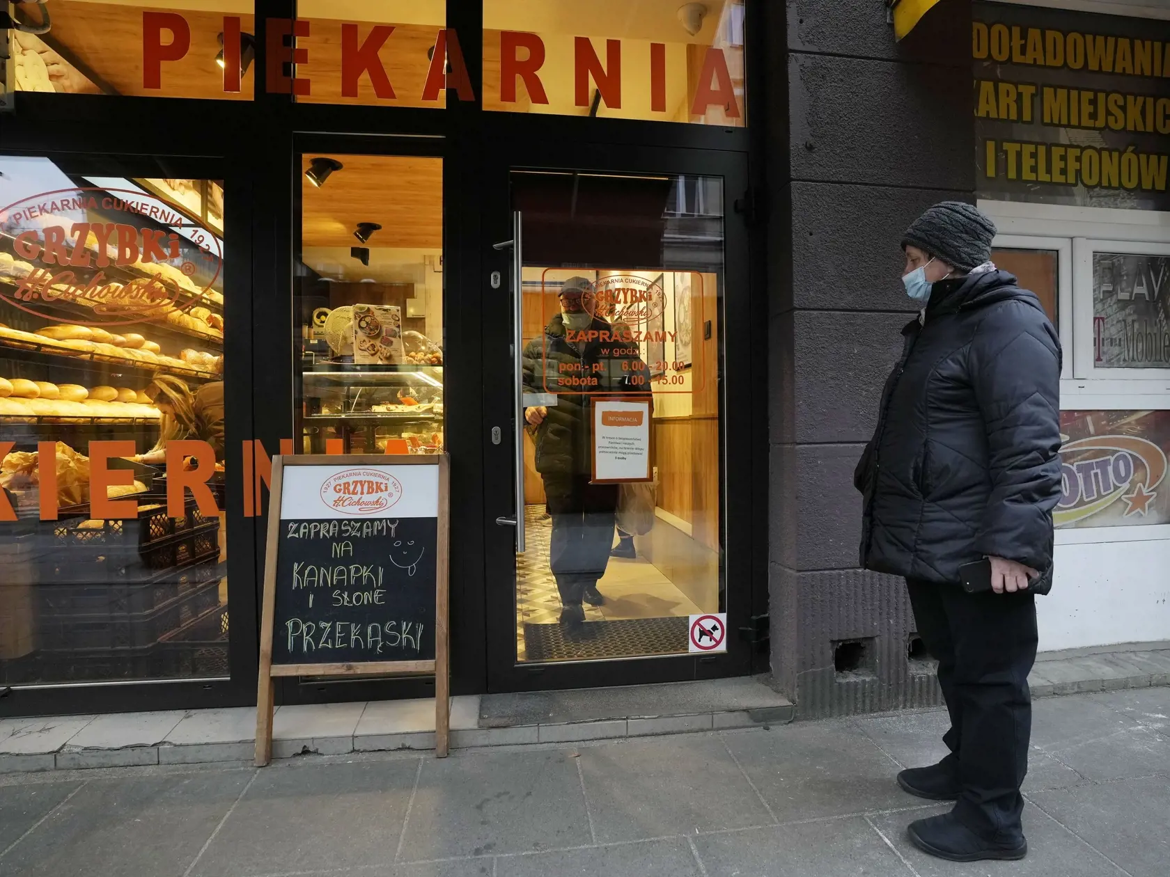 WA 13 Varšava - Zákazníčka s ochranným rúškom čaká pred pekárňou vo Varšave v piatok 26. novembra 2021. Poľsko čelí raketovému nárastu nových prípadov nákazy koronavírusu a úmrtí, ale vláda zatiaľ neplánuje zaviesť lockdown či iné opatrenia. FOTO TASR/AP 

A customer wearing a face mask prepares to leave a bakery, in Warsaw, Poland, on Friday Nov. 26, 2021. Poland is facing skyrocketing COVID-19 infections and deaths but for now the government does not plan any new lockdowns or other restriction