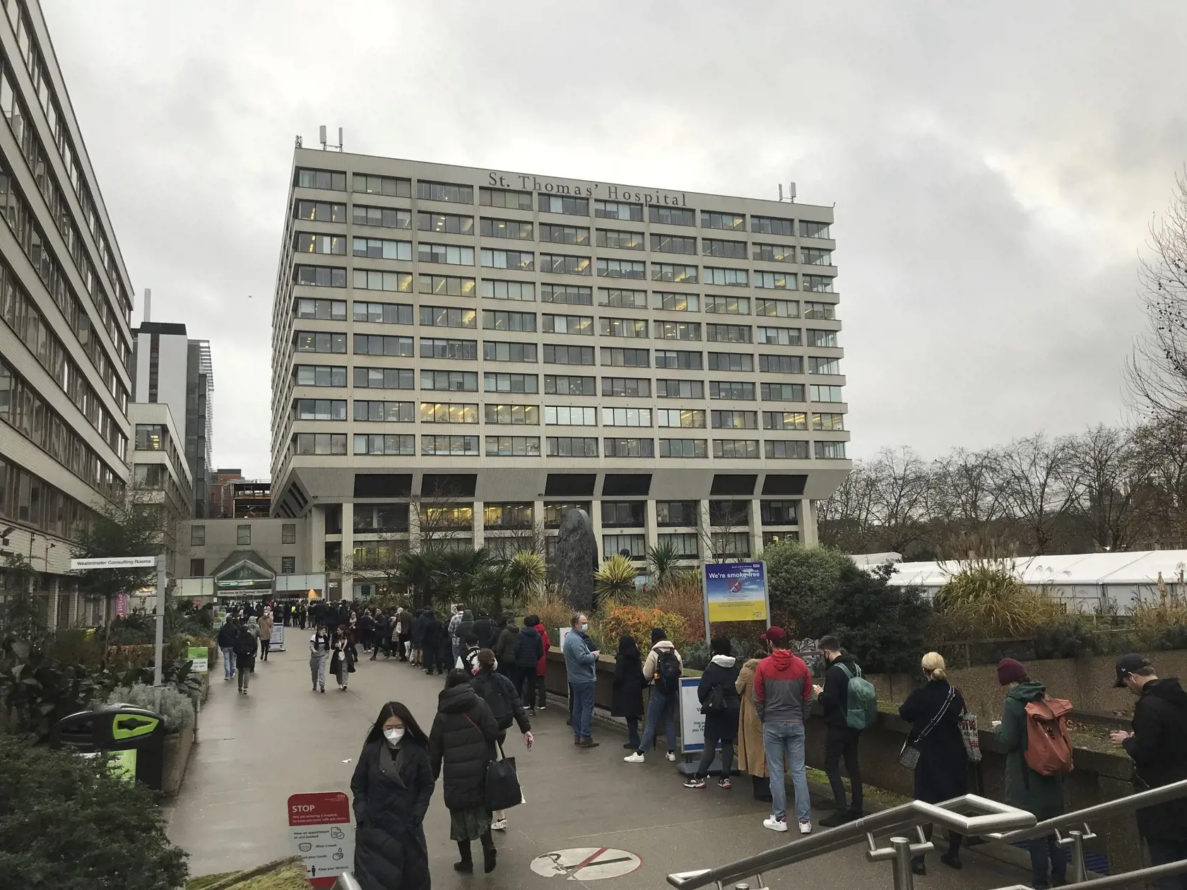 Ľudia stoja v rade na očkovanie treťou posilňujúcou dávkou vakcíny proti ochoreniu COVID-19 pred nemocnicou St Thomas Hospital v Londýne 13. decembra 2021. Nový koronavírusový variant omikron sa šíri "neobyčajným tempom".