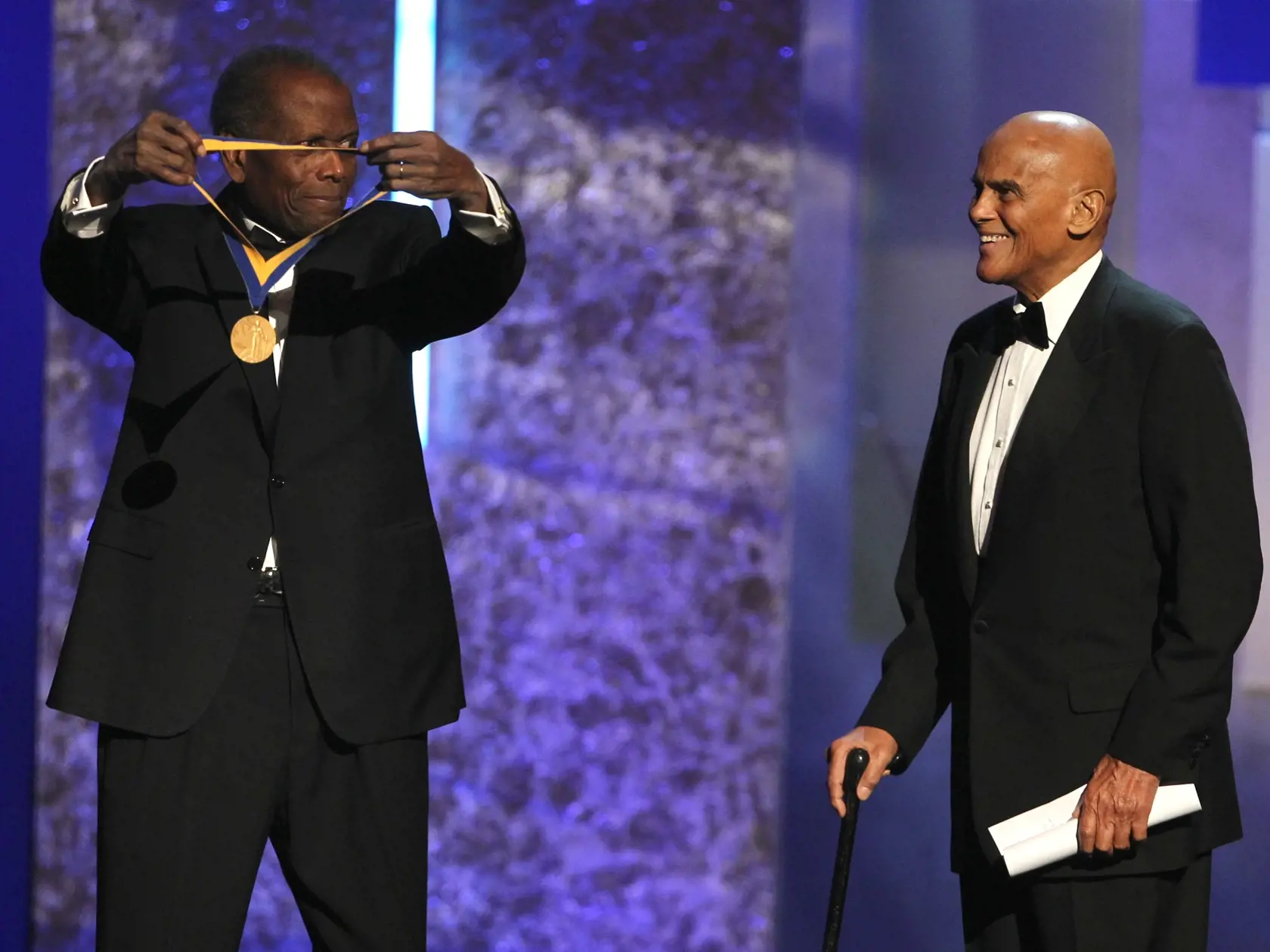 Americký herec Sidney Poitier (vľavo) odovzdáva Spingarnovú medailu spevákovi Harrymu Belafontemu na 44. ročníku odovzdávania cien Národnej asociácie na podporu ľudí s farebnou pleťou (NAACP) NAACP Image Awards 1. februára 2013 v Los Angeles. FOTO TASR/AP