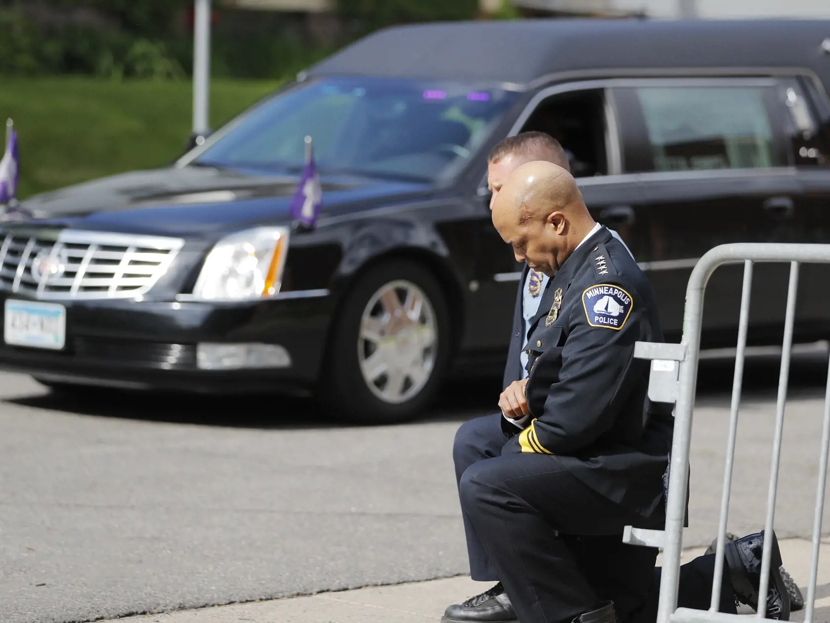 KK7 Minneapolis - Veliteľ polície v Minneapolise Medaria Arradondo (v popredí) si pokľakol na chodníku, keď okolo neho prechádzalo auto pohrebnej služby prevážajúce rakvu s telom Afroameričana Georgea Floyda k miestu konania bohoslužby v North Central University, 4. júna 2020 v Minneapolise. FOTO TASR/AP
Police officers including Minneapolis Police Chief Medaria Arradondo, foreground, take a knee as the body of George Floyd arrives before his memorial services on Thursday, June 4, 2020 in Minnea
