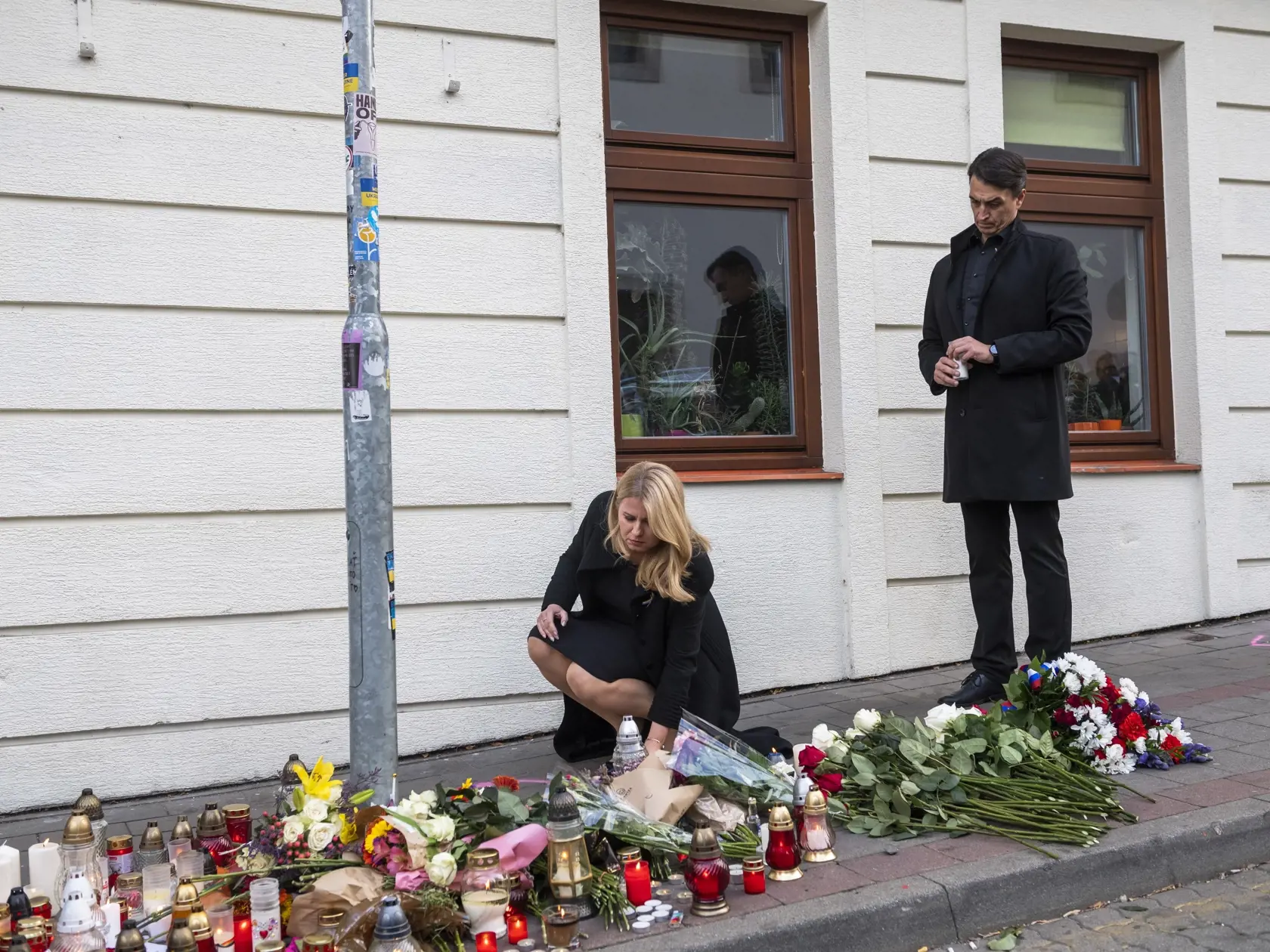 Na snímke prezidentka SR Zuzana Čaputová prišla položiť kyticu a zapáliť sviečku na miesto činu po streľbe na Zámockej ulici, vpravo jej partner Juraj Rizman v Bratislave 13. októbra 2022. FOTO TASR - Jaroslav Novák