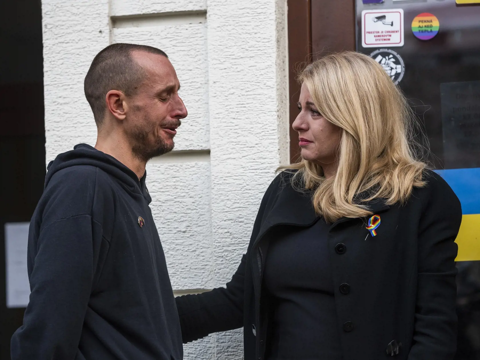 Na snímke prezidentka SR Zuzana Čaputová prišla položiť kyticu a zapáliť sviečku na miesto činu po streľbe na Zámockej ulici, vľavo ju objíma majiteľ podniku Tepláreň Roman Samotný v Bratislave 13. októbra 2022. FOTO TASR - Jaroslav Novák