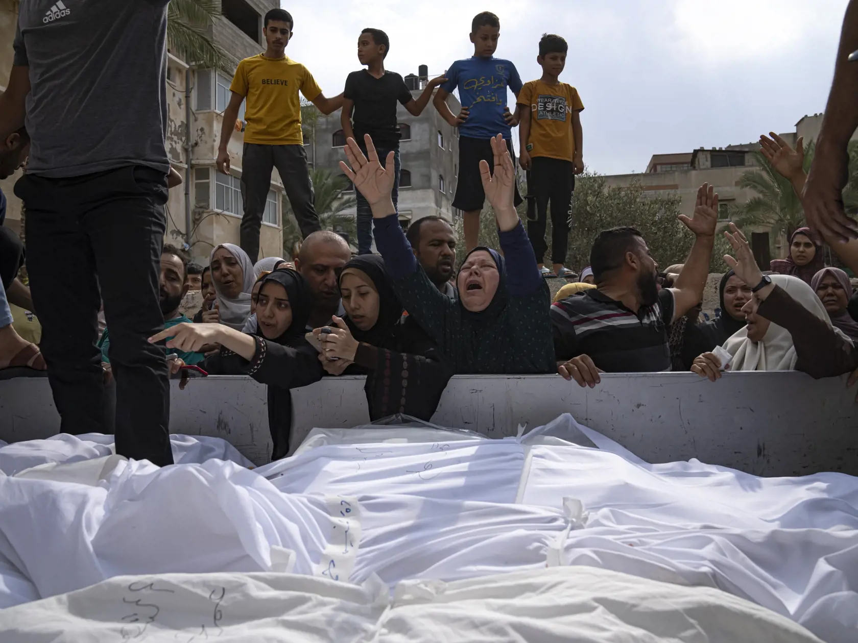 WA 39 Gaza - Príbuzní oplakávajú ľudí, ktorí zahynuli pri izraelskom nálete v meste Gaza v pondelok 9. októbra 2023. Izraelská armáda v pondelok uviedla, že jej príslušníci zabili niekoľko podozrivých ozbrojencov, ktorí na severe krajiny prekročili izraelsko-libanonské hranice.  Hnutie Hamas v sobotu z pásma Gazy zaútočilo tisíckami rakiet na Izrael, pričom jeho militanti súčasne na mnohých miestach prenikli na izraelské územie. Izrael reagoval intenzívnymi leteckými a delostreleckými útokmi na 