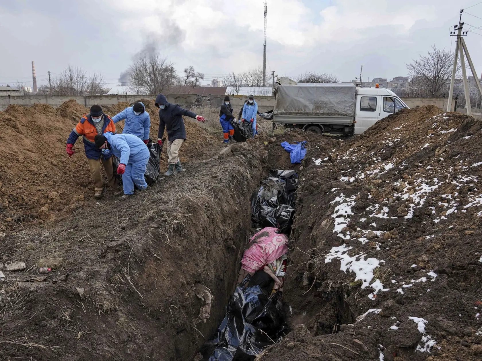 KK61 Mariupol - Na snímke mŕtve telá ukladujú do masového hrobu v Mariupole počas štrnásteho dňa ruskej invázie na Ukrajine v stredu 9. marca 2022. FOTO TASR/AP  

Dead bodies are put into a mass grave on the outskirts of Mariupol, Ukraine, Wednesday, March 9, 2022 as people cannot bury their dead because of the heavy shelling by Russian forces. (AP Photo/Evgeniy Maloletka)