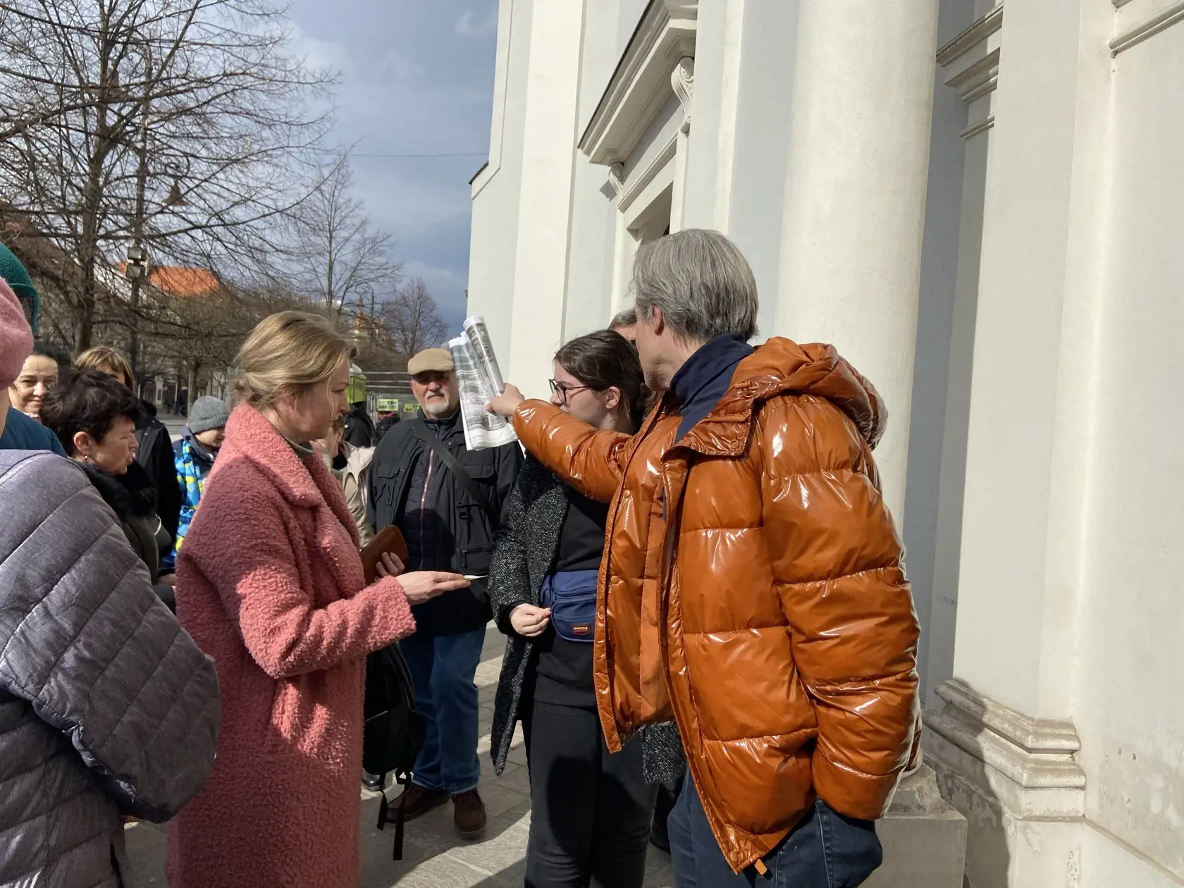 Milan organizuje prítomných, aby prešli ďalej na Hlavnú ulicu, aby mali lepší výhľad na Seminárny kostol.