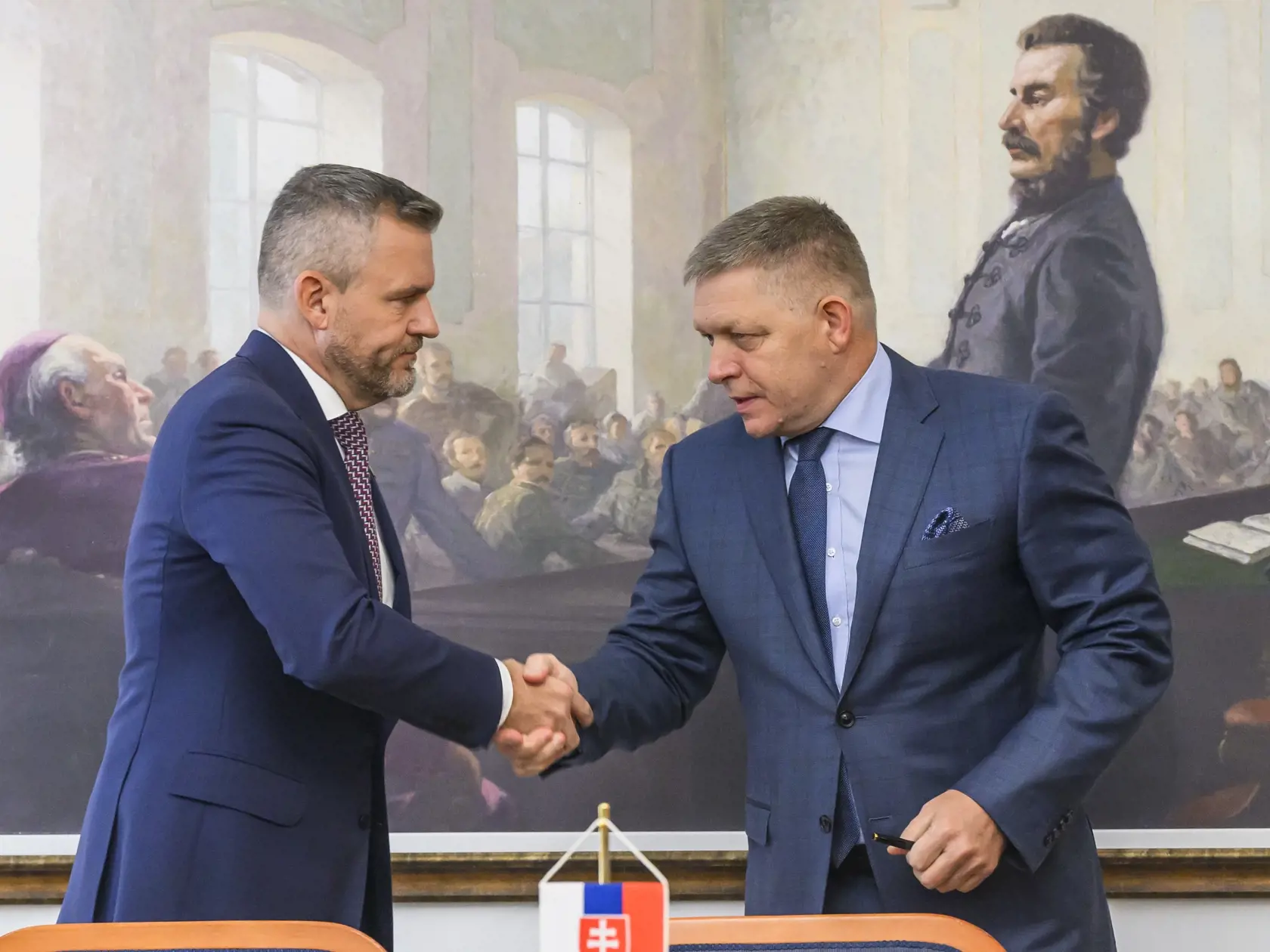 Na snímke zľava predseda HLAS-SD Peter Pellegrini a predseda SMER-SD Robert Fico si podávajú ruky počas slávnostného aktu podpisu memoranda o porozumení strán SMER-SD, HLAS-SD a SNS v historickej budove NR SR v Bratislave 11. októbra 2023.
