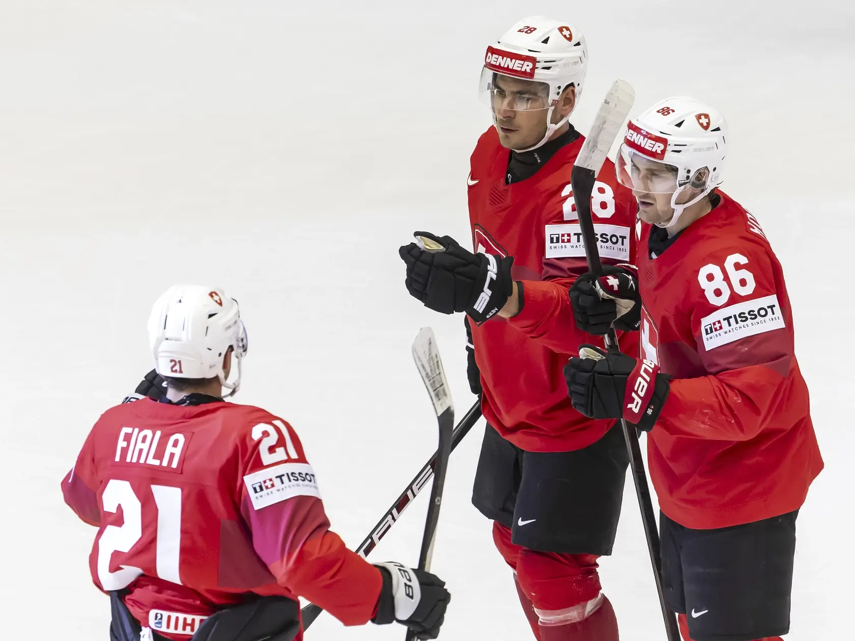 Švajčiarski hokejisti Timo Meier (uprostred) a Janis Jerome Moser (vpravo) sa tešia z gólu, ktorý strelil ich spoluhráč Kevin Fiala (vľavo).