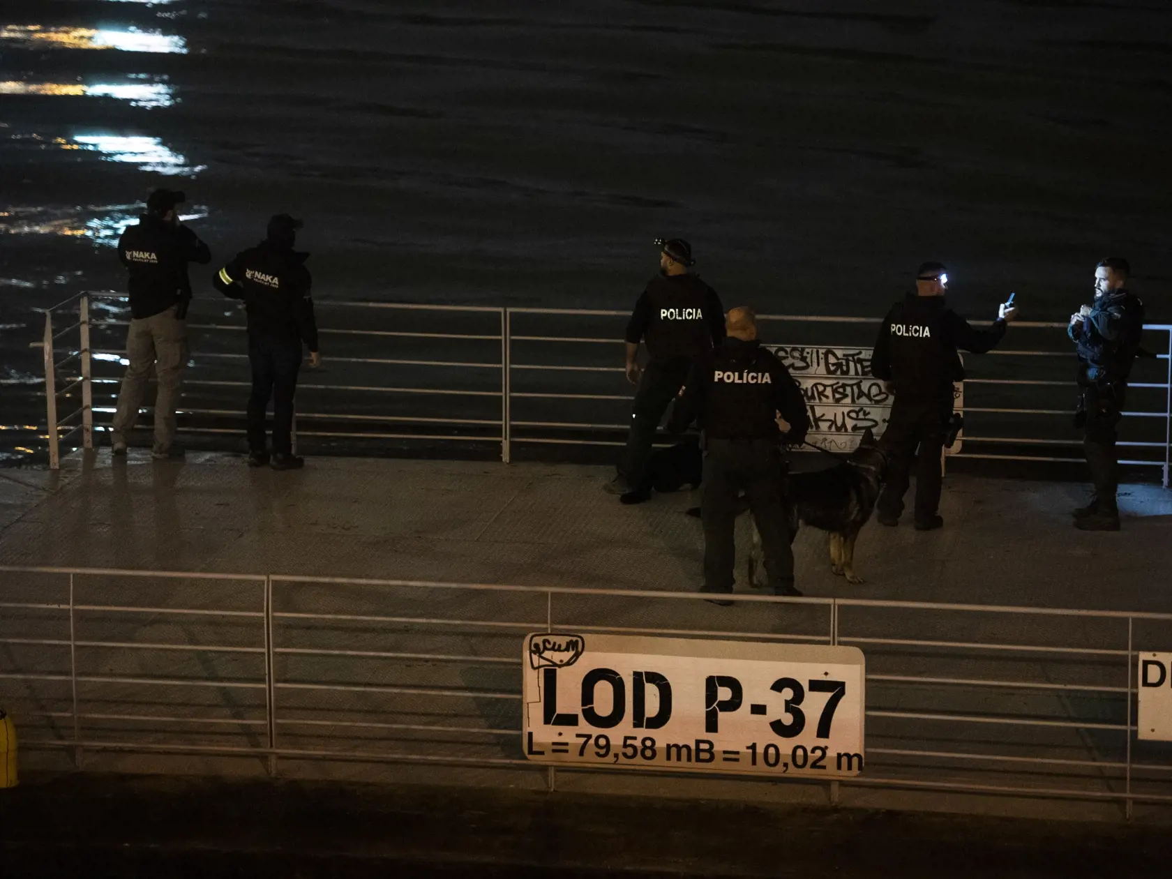 Na snímke policajti na lodi prehľadávajú nábrežie Dunaja po streľbe na Zámockej ulici v Bratislave 12. októbra 2022. Po páchateľovi, ktorý mal v stredu večer strieľať v Bratislave na Zámockej ulici a je na úteku, pátra v týchto chvíľach aj policajný vrtuľník. FOTO TASR - Jaroslav Novák