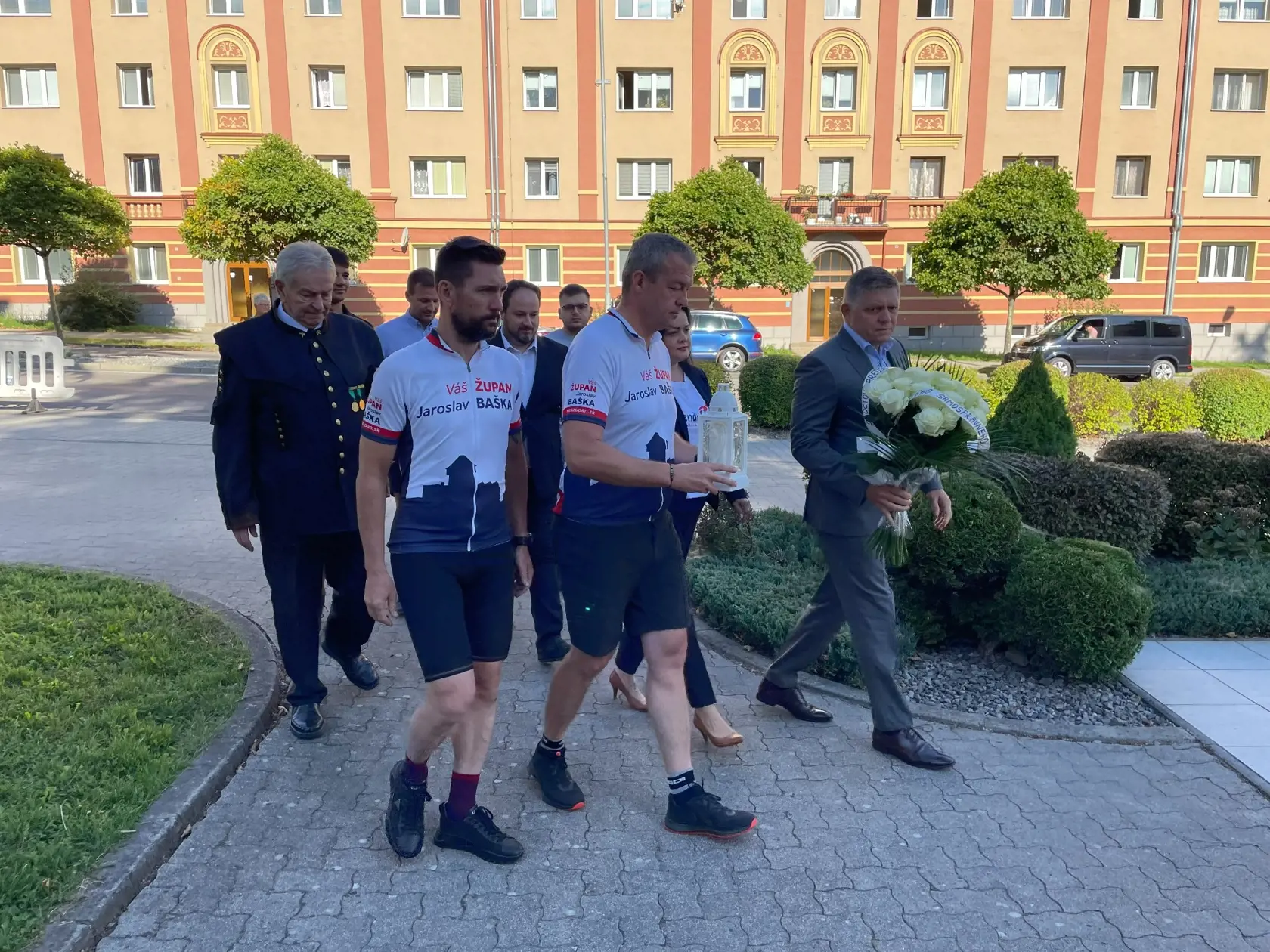 Muži v športových dresoch s reklamou na smeráckeho župana v spoločnosti Róberta Fica.