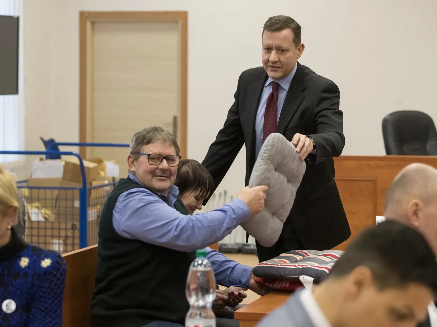 Siedme pojednávanie na Špecializovanom trestnom súde v Pezinku vo veci vraždy investigatívneho novinára Jána Kuciaka a jeho snúbenice Martiny Kušnírovej. Na snímke sú rodičia Jána Kuciaka so svojim právnym zástupcom Danielom Lipšicom, ktorý im pred začiatkom dlhého súdneho pojendávania podáva podsedáky.