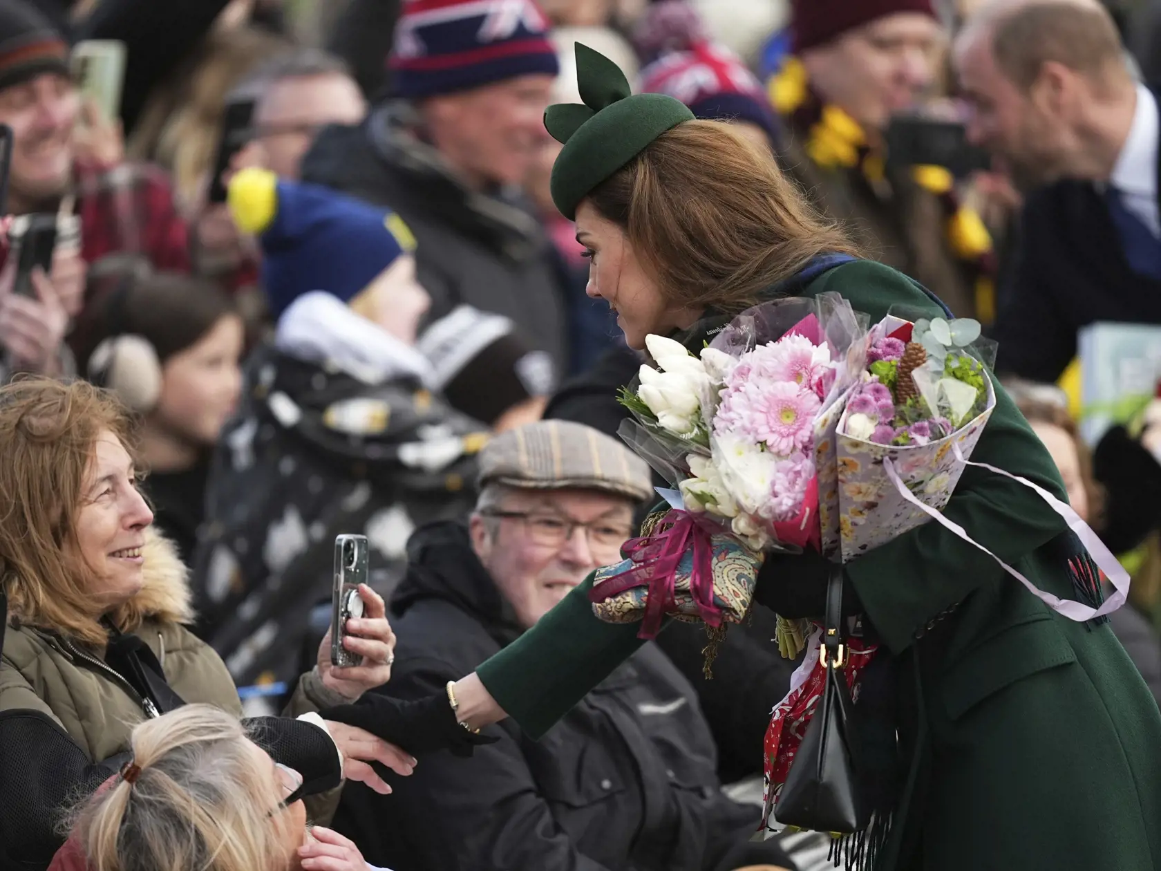 Kate, princezná z Walesu, ktorá drží kyticu kvetov, podáva ruku žene v dave po tradičnej vianočnej omši v anglickom Sandringhame v stredu 25. decembra 2024. FOTO TASR/AP