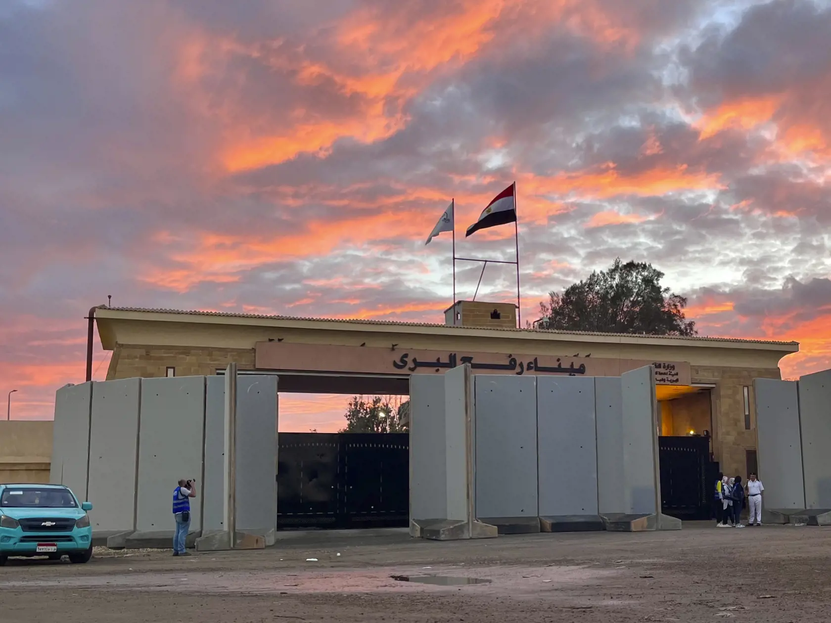 JB 14 Rafah - Policajti stoja na hraničnom priechode Rafah medzi Egyptom a Gazou 17. októbra 2023, kde parkuje konvoj s humanitárnou pomocou pre pásmo Gazy. Konvoje s humanitárnou pomocou sa v utorok pohli z egyptského vnútrozemia smerom k hraničnému priechodu Rafah spájajúcemu Egypt a pásmo Gazy, informuje TASR podľa správy agentúry AFP. Predstaviteľ Červeného kríža váhavo potvrdil, že rokovania o vstupe konvojov do pásma Gazy a odchode cudzincov sa blížia k záveru. Potvrdil, že na egyptskej st