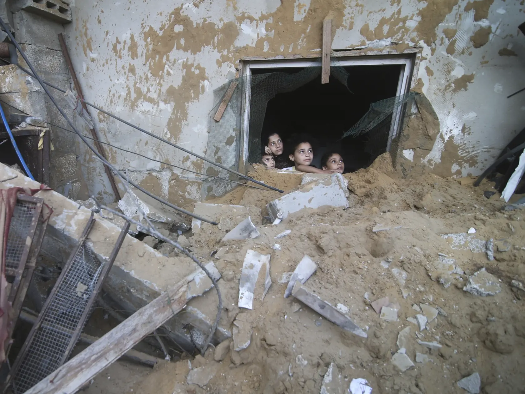 WA 2 Rafah - Palestínske deti sa pozerajú zo zničeného domu po raketovom útoku izraelskej armády v palestinskom meste v južnom cípe Pásma Gazy, ktorého časť susedí s Egyptom v sobotu 14. októbra 2023. FOTO TASR/AP

Palestinian children look at the building of the Zanon family, destroyed in Israeli airstrikes in Rafah, Gaza Strip, Saturday, Oct. 14, 2023. (AP Photo/Hatem Ali)