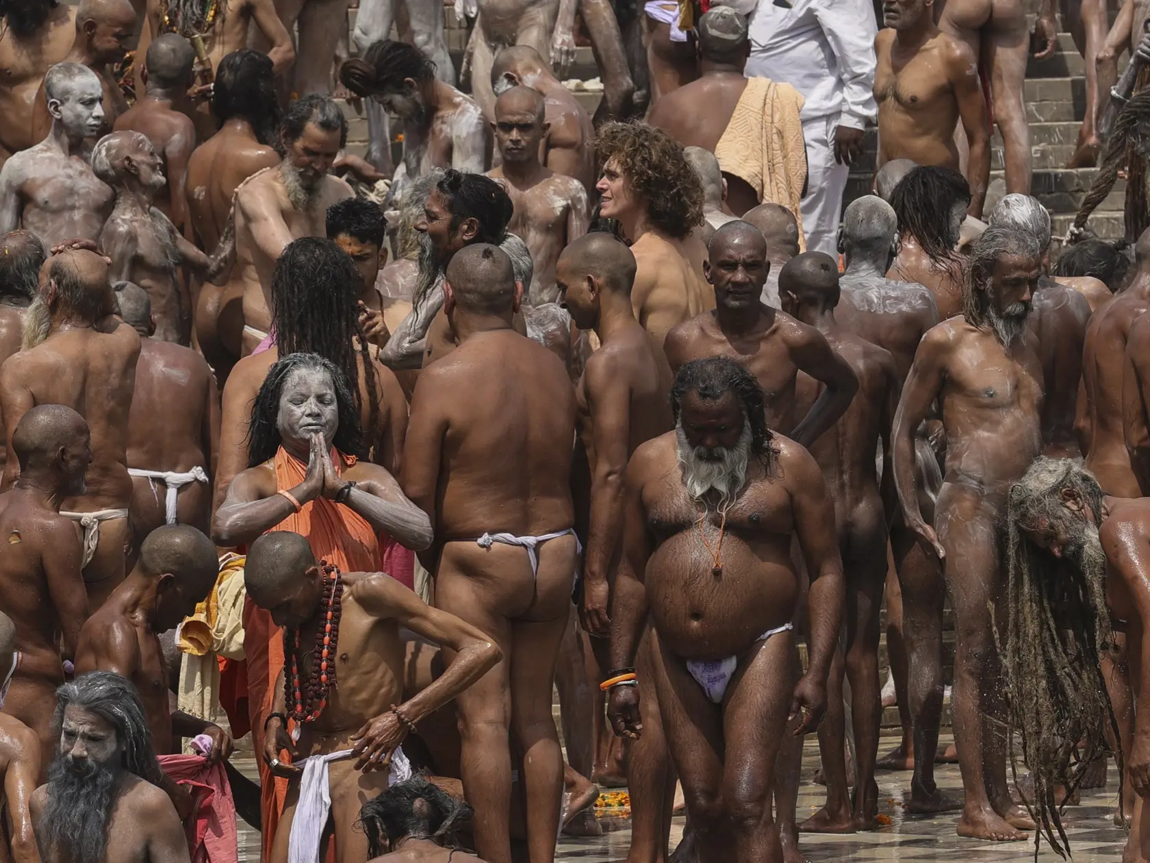 Na snímke Naga sádhuovia, nahí hinduistickí svätí muži podstupujú rituálny kúpeľ v rieke Gange počas sviatku Kumbh Méla (sviatku džbánov) v indickom Haridvare 12. apríla 2021. Kumbh Méla je jedným z najväčších svetových náboženských zhromaždení a zúčastňujú sa ho milióny hinduistických pútnikov, ktorí sa ponárajú do posvätnej rieky Gangy, aby sa očistili a zmyli svoje hriechy. Po veľkých zhromaždeniach sa situácia radikálne zhoršila. FOTO TASR/AP