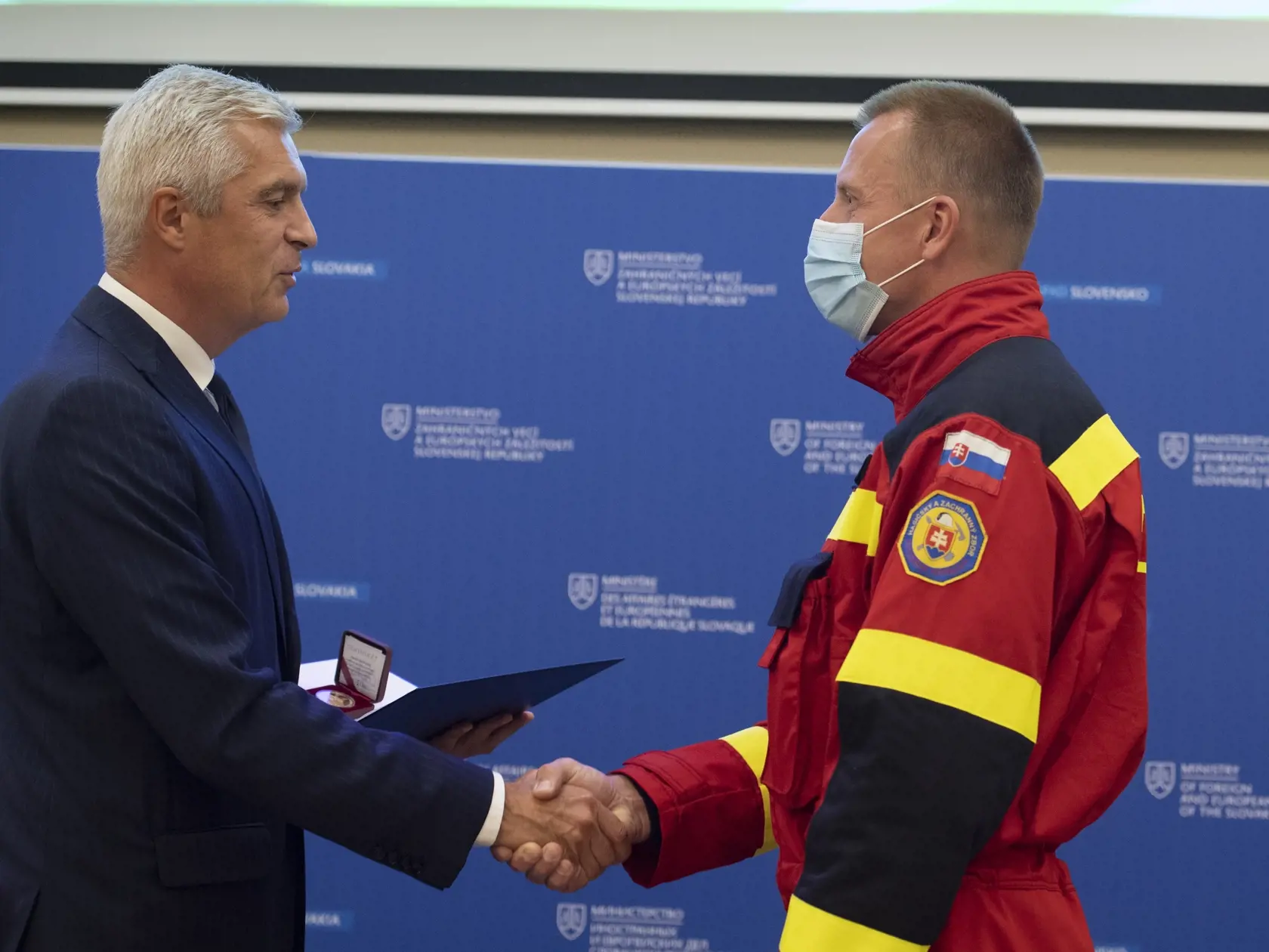 Na snímke vľavo minister zahraničných vecí a európskych záležitostí SR Ivan Korčok odovzdáva zlatú plaketu do rúk veliteľovi pozemného hasenia lesných požiarov Hasičského a záchranného zboru SR Petrovi Kovalíkovi, ktorý so svojím tímom bojovali v auguste (2021) s ničivými požiarmi v Grécku. V Bratislave 31. augusta 2021.  FOTO TASR - Pavel Neubauer
	