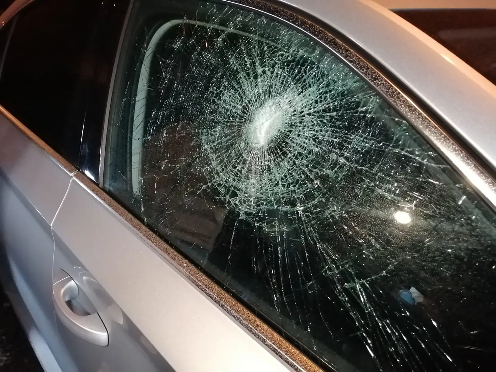 Na snímke je stranícke auto Roberta Fica s rozbitým oknom.