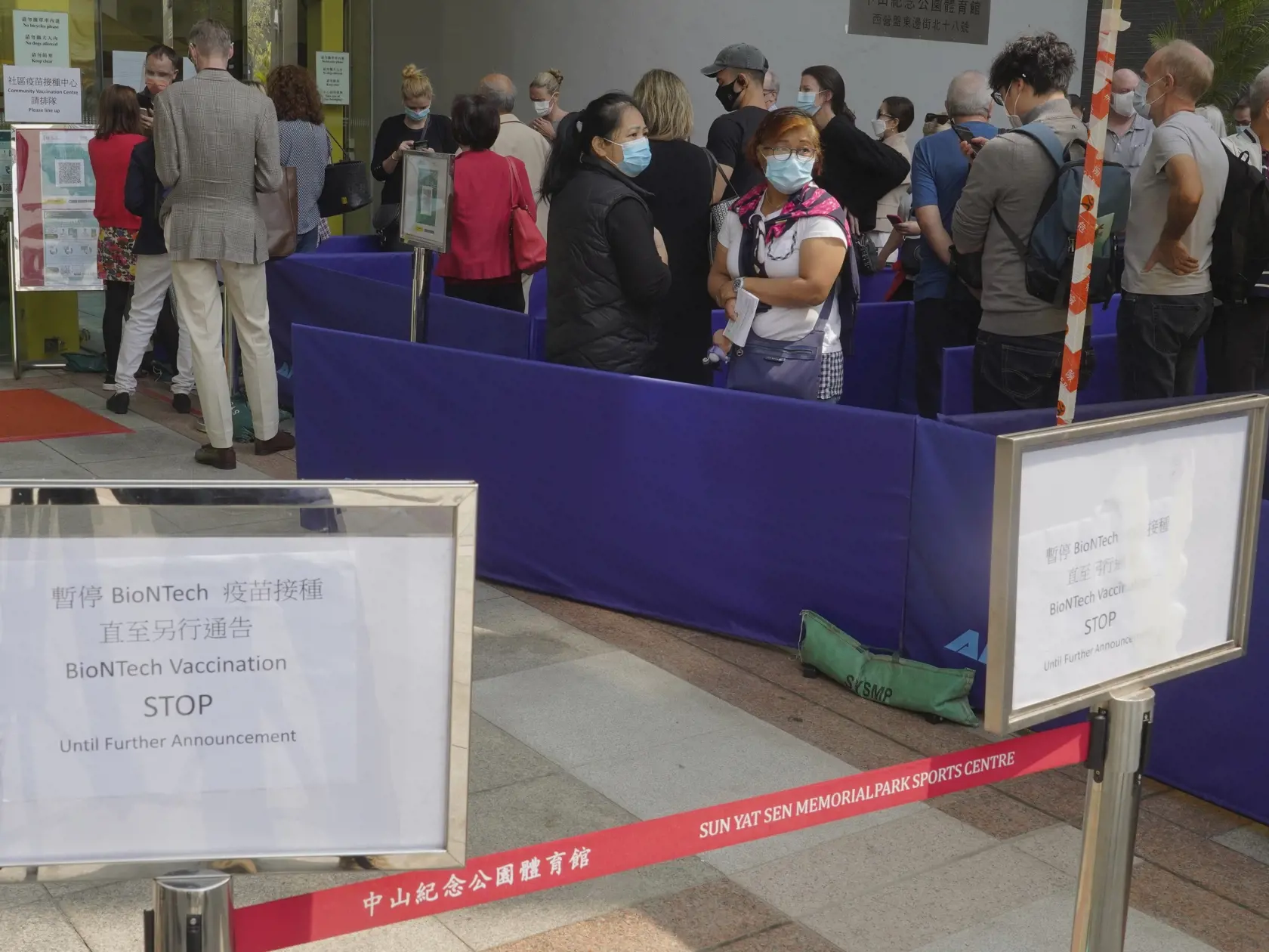 Ľudia čakajú v rade pred vakcinačným centrom na očkovanie vakcínou od spoločností PFizer/BionTech v Hongongu. Hongkong a Macao v stredu pozastavili očkovanie vakcínou proti koronavírusu od spoločností Pfizer/BioNTech po tom, čo dostali informáciu o problémoch s balením jednej zo šarží tejto očkovacej látky. Ú