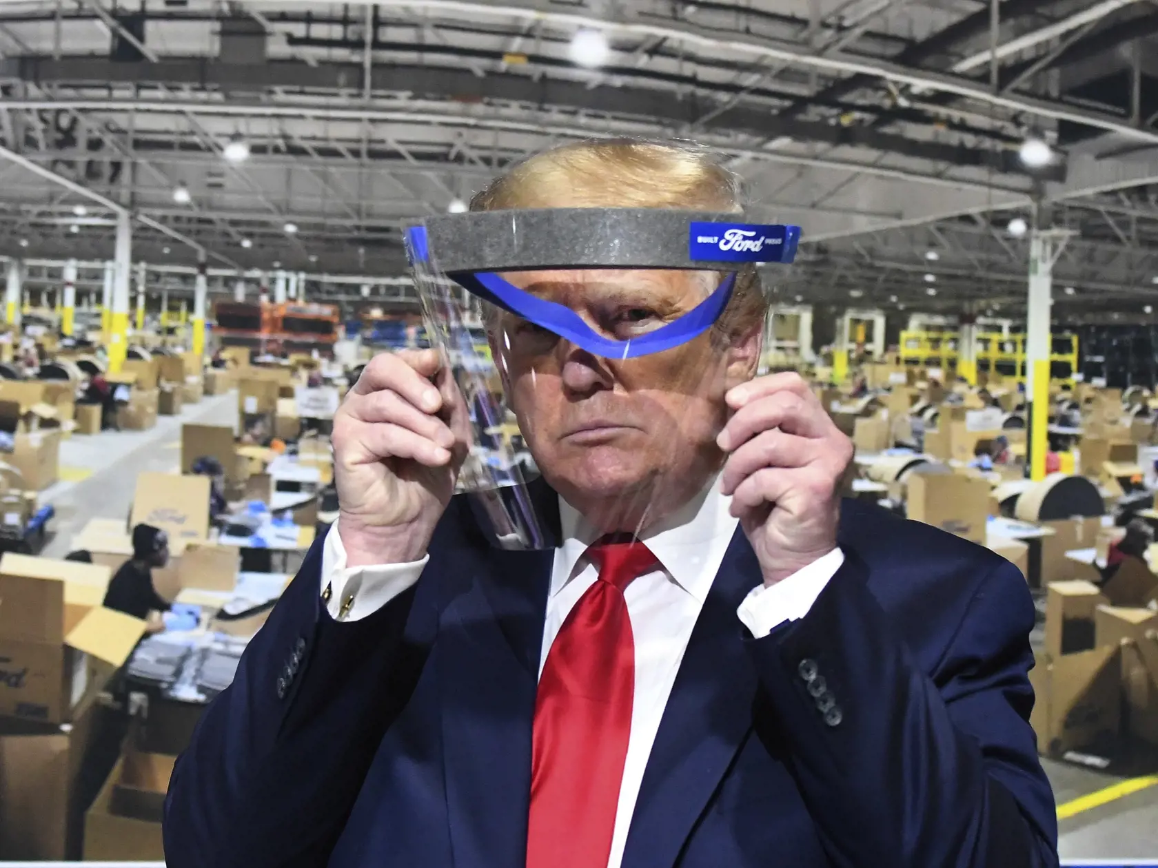 WA 5 Ypsilanti - Americký prezident Donald Trump si skúša ochranný štít počas prehliadky v závode automobilky Ford v meste Ypsilanti v americkom štáte Michigan vo štvrtok 21. mája 2020, ktorý prešiel na výrobu respirátorov a iného lekárskeho vybavenia na boj proti chorobe COVID-19. FOTO TASR/AP 

President Donald Trump looks through a face shield, in front of poster of the manufacturing of these shields, while touring Ford Motor Co.'s Rawsonville Components Plant in Ypsilanti, Michigan on Thursd