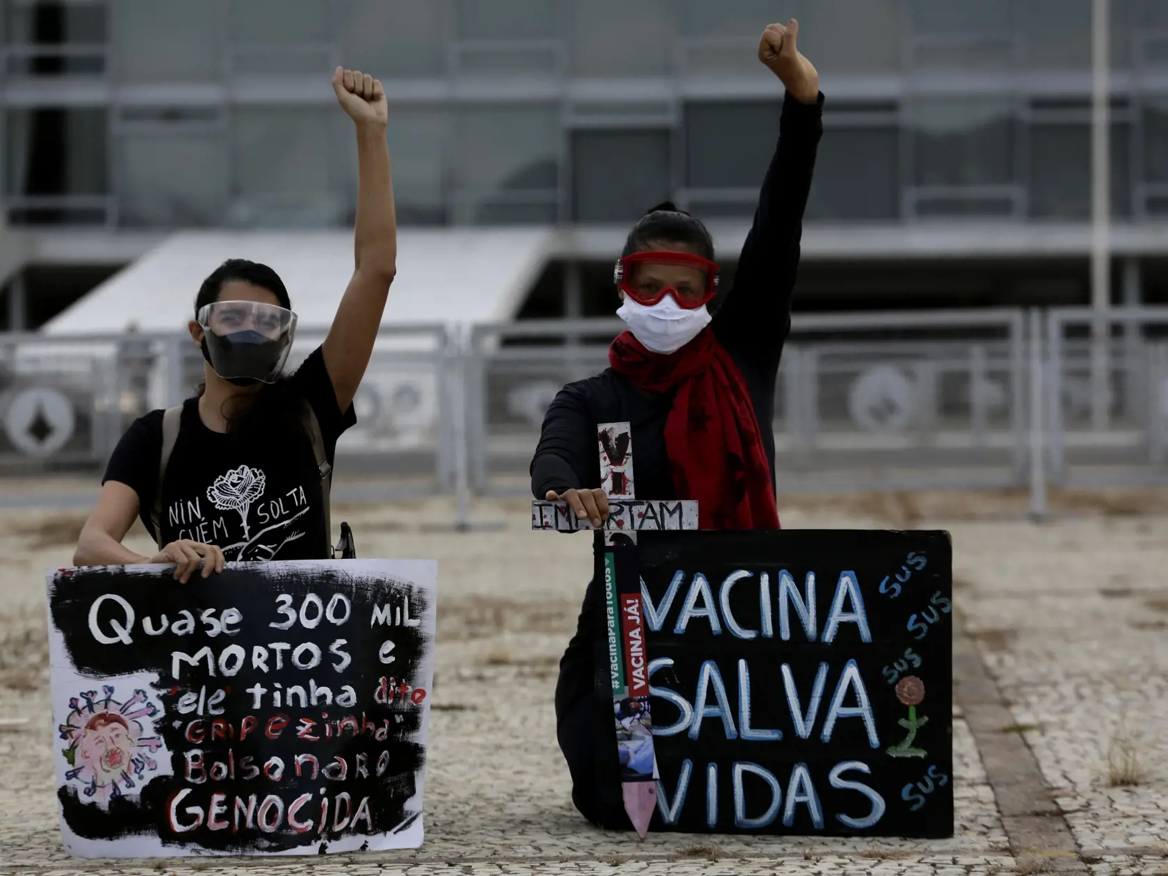 WA 10 Brazília - Demonštranti držia transparenty s nápismi v portugalčine "Očkovanie zachraňuje životy (vpravo)" a "Takmer 300-tisíc úmrtí" počas protestu proti brazílskemu prezidentovi Jairovi Bolsonarovi, ktorý spochybňuje koronavírusovú pandémiu pred prezidentským palácom v Brazílii v piatok 19. marca 2021. FOTO TASR/AP 

Demonstrators protest the president's handling of the COVID-19 pandemic outside Planalto presidential palace in Brasilia, Brazil, Friday, March 19, 2021. The signs read in P