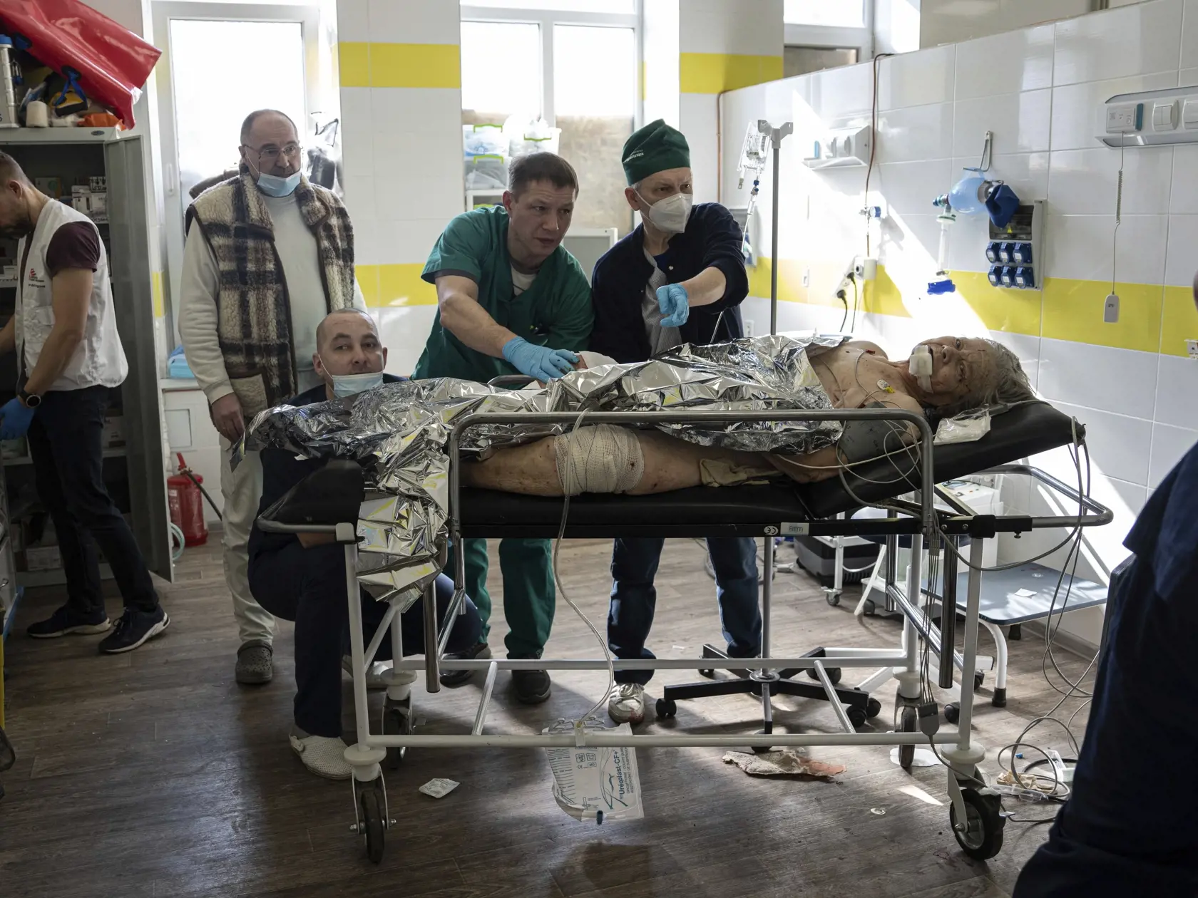Lekári ošetrujú zranenú miestnu ženu po ostreľovaní obytnej štvrte ruskou armádou v meste Kosťantynivka v Doneckej oblasti na východe Ukrajiny v piatok 10. marca 2023.