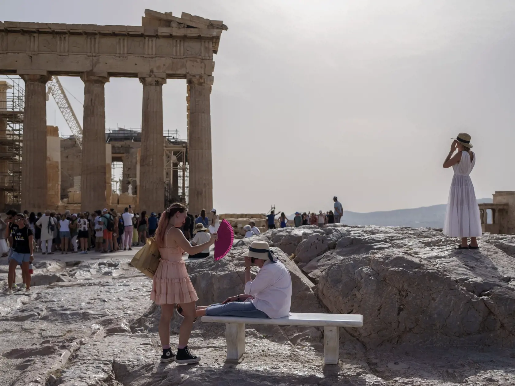 JB 22 Atémy - Turistka osviežuje vejárom ženu na lavičke pred BC Parthenonom v starobylej Akropole v centrálnych Aténach 12. júna 2024. Aténska Akropola, najnavštevovanejšie turistické miesto v Grécku, bola v stredu počas najväčších horúčav pre verejnosť zatvorená, oznámilo tamojšie ministerstvo kultúry. TASR o tom informuje podľa agentúry AFP. V stredu a vo štvrtok počas prvej tohtoročnej vlny horúčav očakávajú v Aténach teplotu až 43 stupňov Celzia, spresnilo ministerstvo. Horúčavy v Grécku by