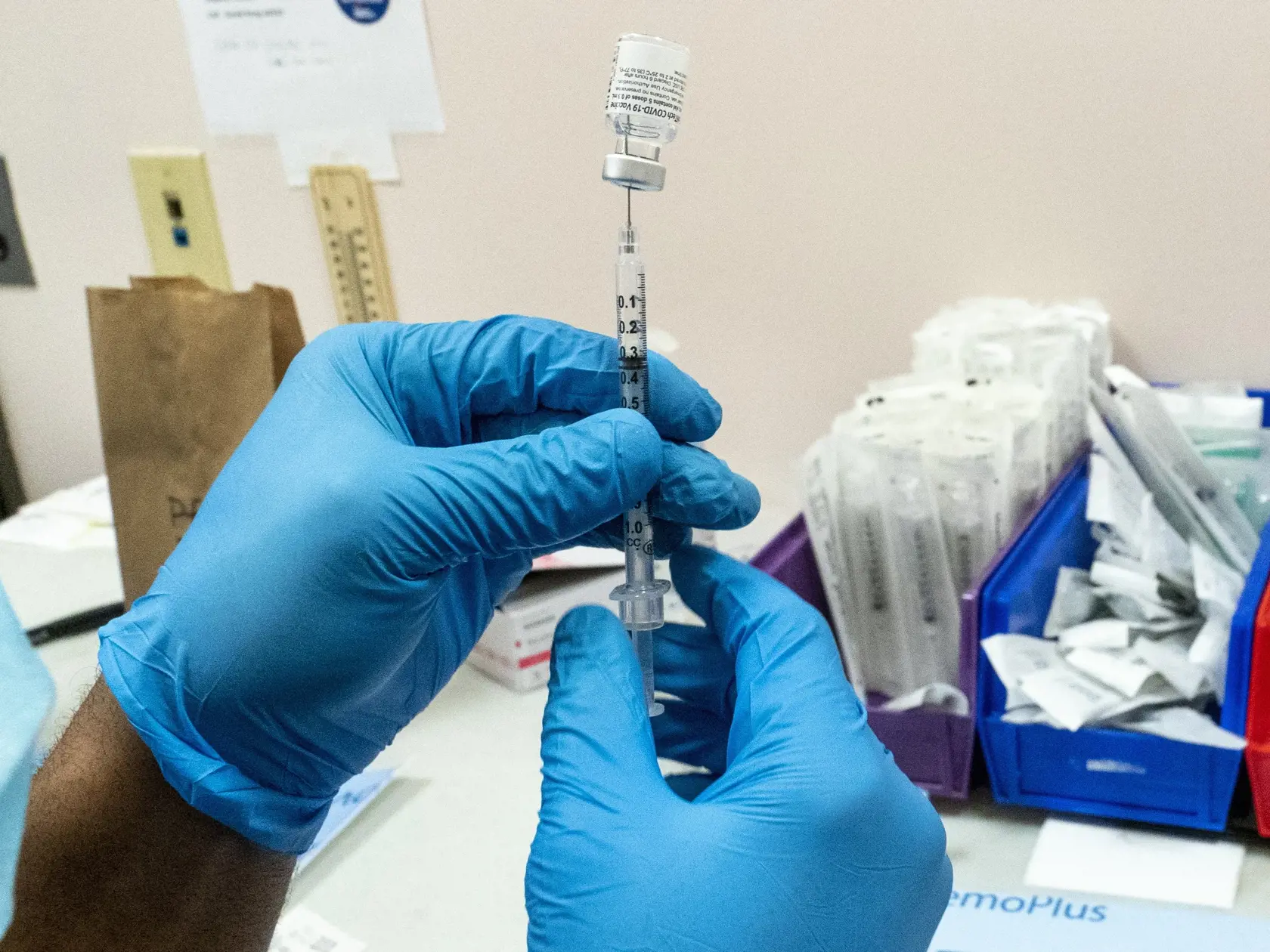 Na archívnej snímke lekár naťahuje injekčnou striekačkou z ampulky vakcínu proti ochoreniu COVID-10 od spoločností Pfizer/BioNTech.