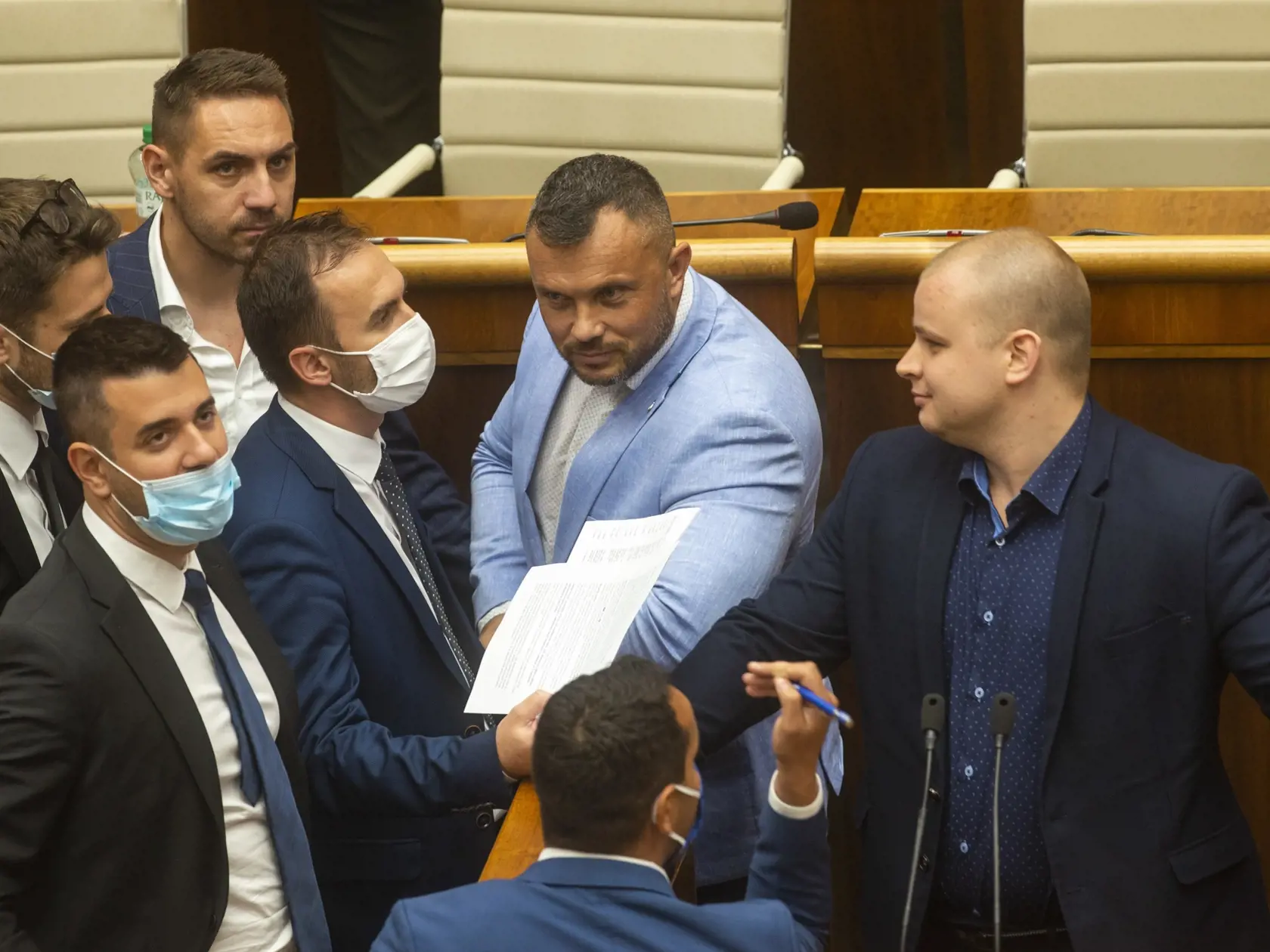 Na snímke sprava poslanci NR SR za stranu ĽSNS Milan Mazurek a Miroslav Suja bránia poslancovi Michalovi Šipošovi (tretí sprava) z OĽaNO v rozprave počas mimoriadnej schôdze, na ktorej premiér Igor Matovič (OĽaNO) čelí po prvý raz od nástupu do funkcie odvolávaniu vo štvrtok 23. júla 2020 v Bratislave. Návrh vyslovenie nedôvery predložili opoziční poslanci Juraj Blanár (Smer-SD) a Richard Raši (nezaradený) po medializácii podozrení, že Matovičova diplomová práca je plagiát. FOTO TASR - Jakub Kot