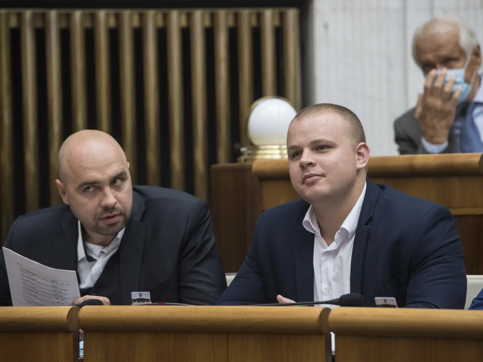 Na snímke poslanci NR SR, zľava Andrej Medvecký a Milan Mazurek (obaja ĽSNS), ktorí si odmietli nasadiť rúško aj po napomenutí predsedom parlamentu SR Borisom Kollárom (Sme rodina), vpravo hore Dušan Galis (Smer-SD) počas 11. schôdze Národnej rady  SR v Bratislave 2. septembra 2020. FOTO TASR - Martin Baumann