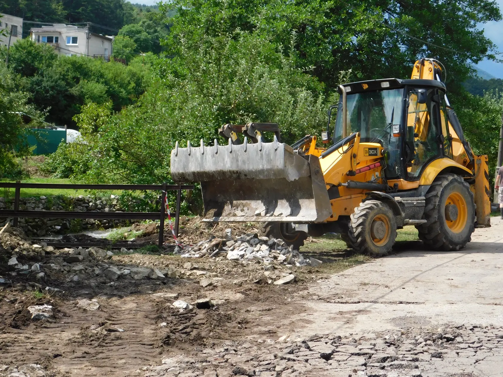 Na snímke stroj odstraňuje škody po povodni v obci Valaská Belá v pondelok 2. augusta 2021.