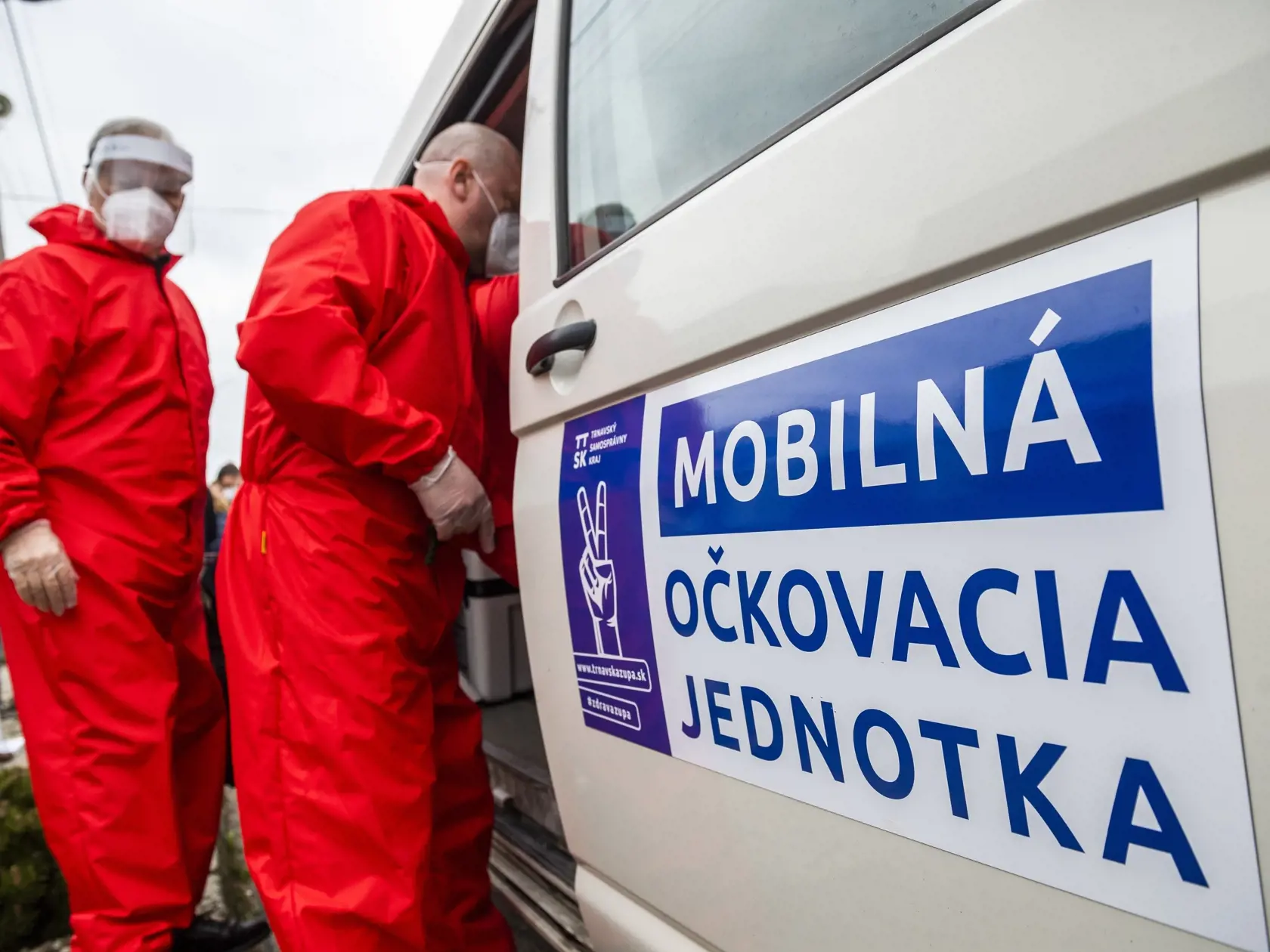 Na snímke členovia mobilnej očkovacej jednotky odnášajú mobilnú chladničku s vakcínou od spoločností Pfizer/BionTech proti ochoreniu Covid-19 po zaočkovaní pacientky počas tlačovej konferencie k výjazdovému očkovaniu imobilných pacientov v domácnostiach v trnavskej mestskej časti Modranka 16. apríla 2021. FOTO TASR - Jaroslav Novák	
