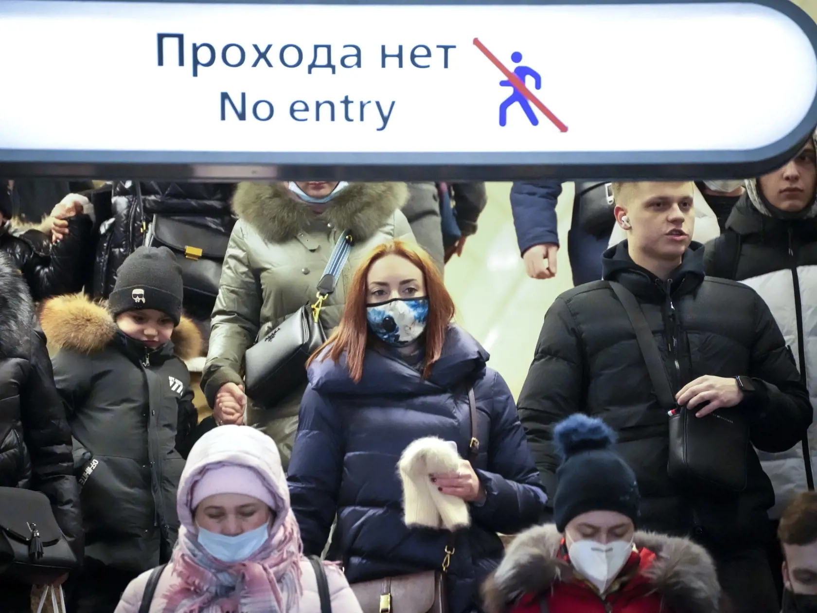 Ľudia s ochrannými rúškami kráčajú na stanici metra v Petrohrade 21. januára 2022. Rusko v piatok oznámilo rekordný denný prírastok počtu nakazených koronavírusom – za 24 hodín pribudlo 49.513 prípadov.